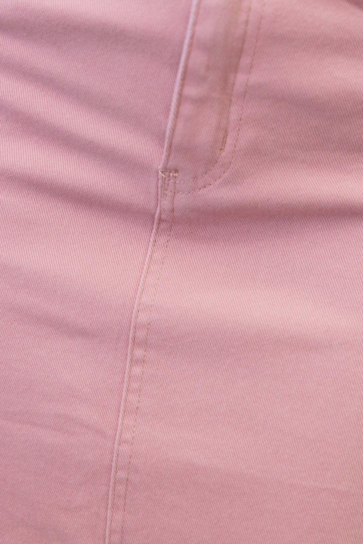 Close-up of the fabric texture and stitching on a pink denim skirt, showcasing its quality and design details.