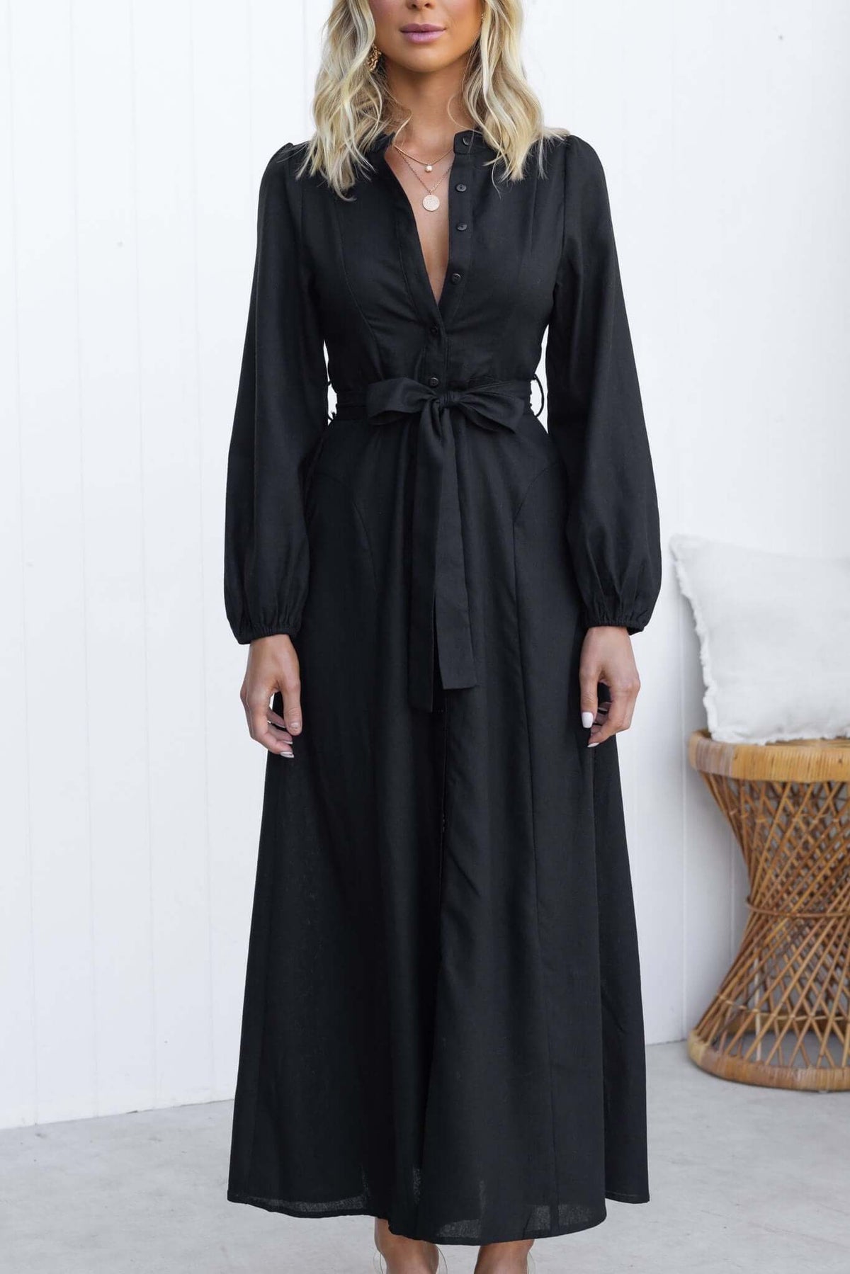Black Delgado maxi dress with button-up front, Elastic sleeves, removable tie, and pockets, styled on model.
