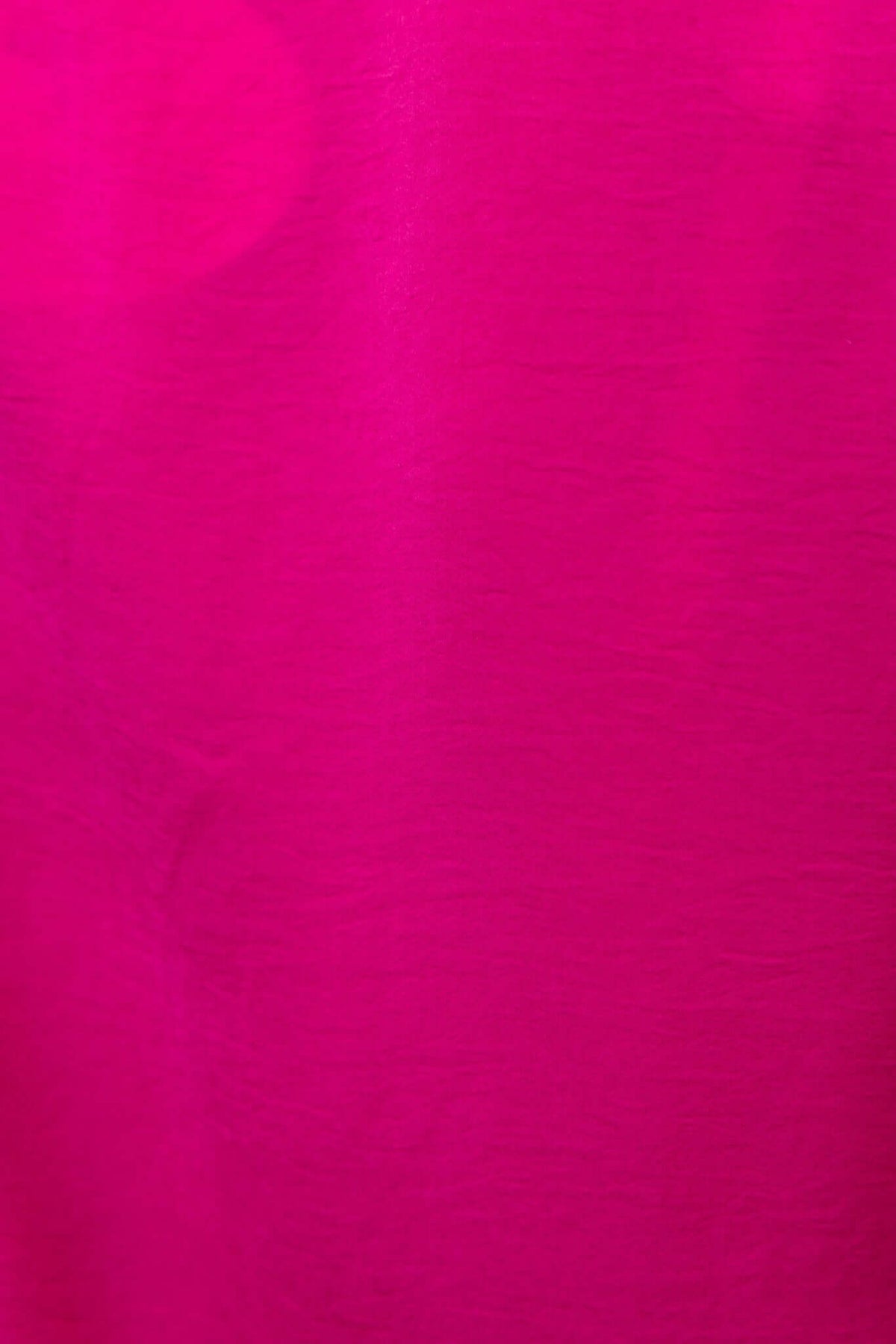 Close-up of Ravia Shirt fabric in vibrant pink, showcasing smooth texture and rich color.