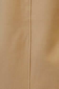 Close-up of the seam detail on a beige fabric, showcasing a smooth, textured surface for a stylish coat.