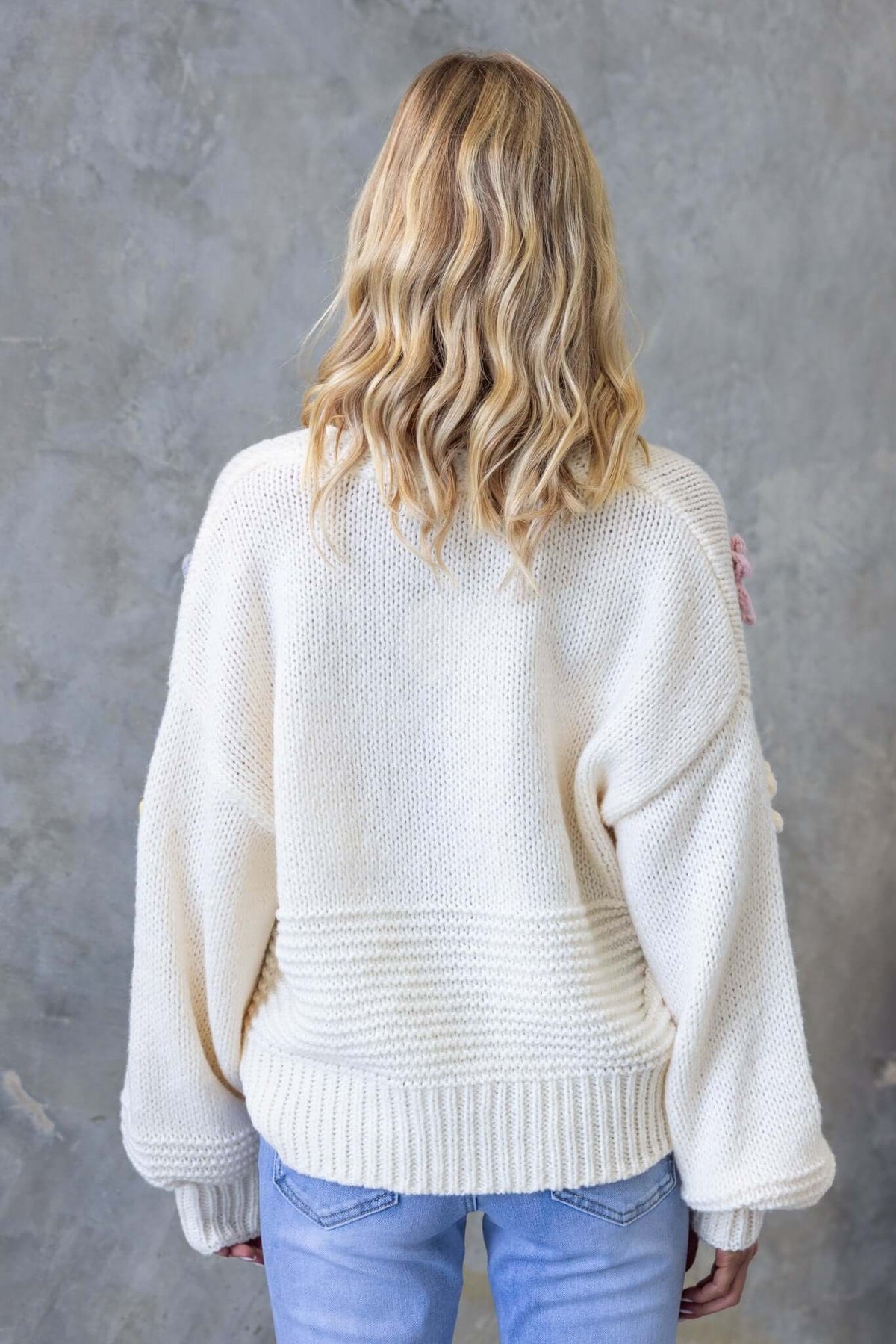 Back view of Love Bug Cardigan in cream with a relaxed fit, showcasing textured knit fabric and wide sleeves.