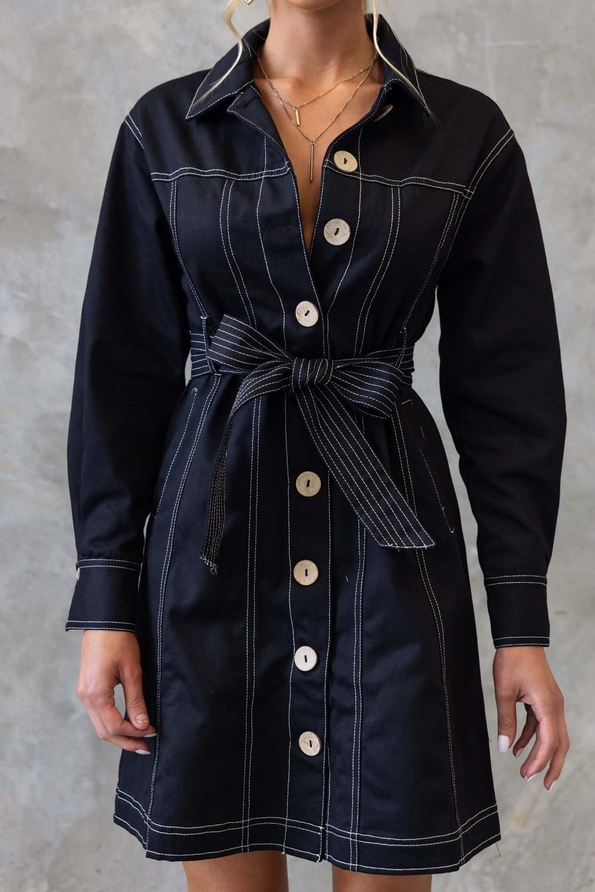 Lisa Denim Dress in black featuring a button-up front, collar, hip pockets, and a removable belt.