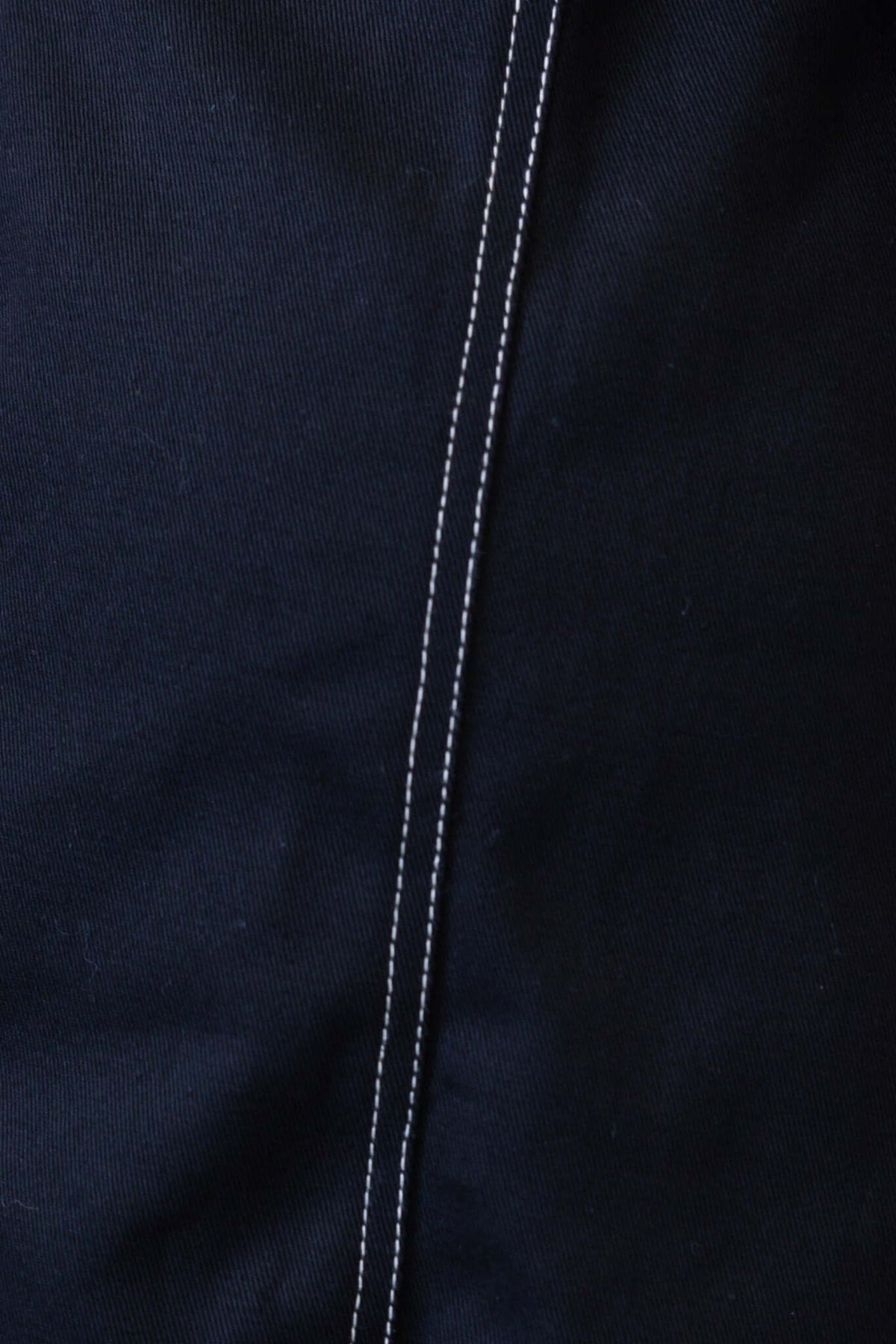 Close-up of black denim fabric showcasing white stitching detail for Lisa Denim Dress.