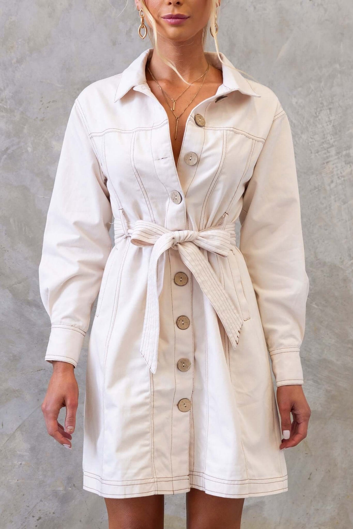 Lisa denim dress in cream with a button-up front, collar, tie belt, and pockets, perfect for a stylish look.