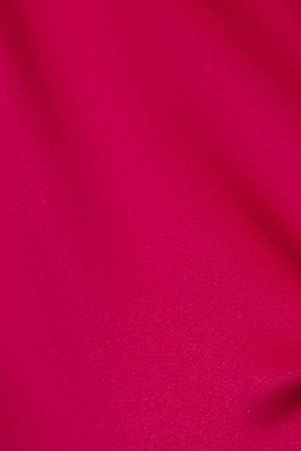 Close-up of vibrant fuchsia fabric showcasing a satin look and feel, perfect for clothing like dresses.