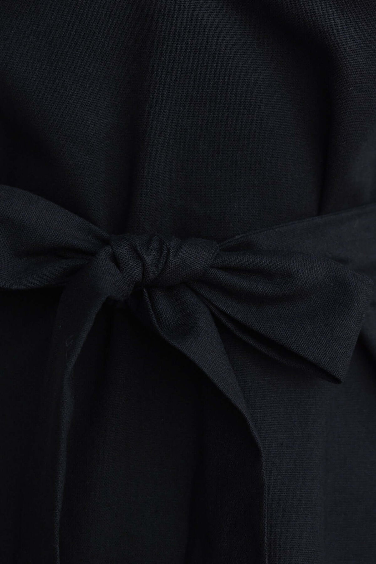 Close-up of the tie detail on the Thorelle black maxi dress, showcasing its linen texture and elegant style.