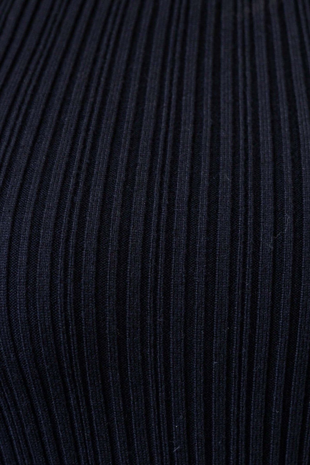 Close-up of the ribbed knit fabric of the Varallo Maxi Dress in black, showcasing its stretchy material and texture.
