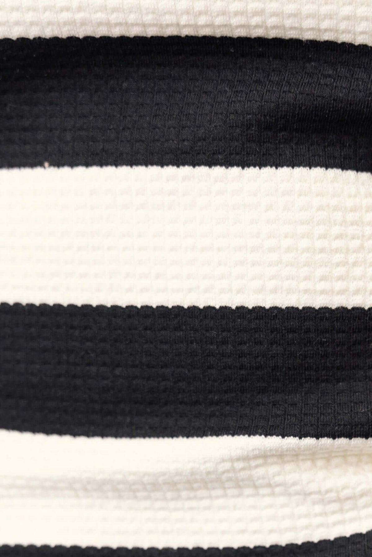 Close-up of textured fabric in black and white stripes, showcasing the material of the Caserta Maxi Dress.