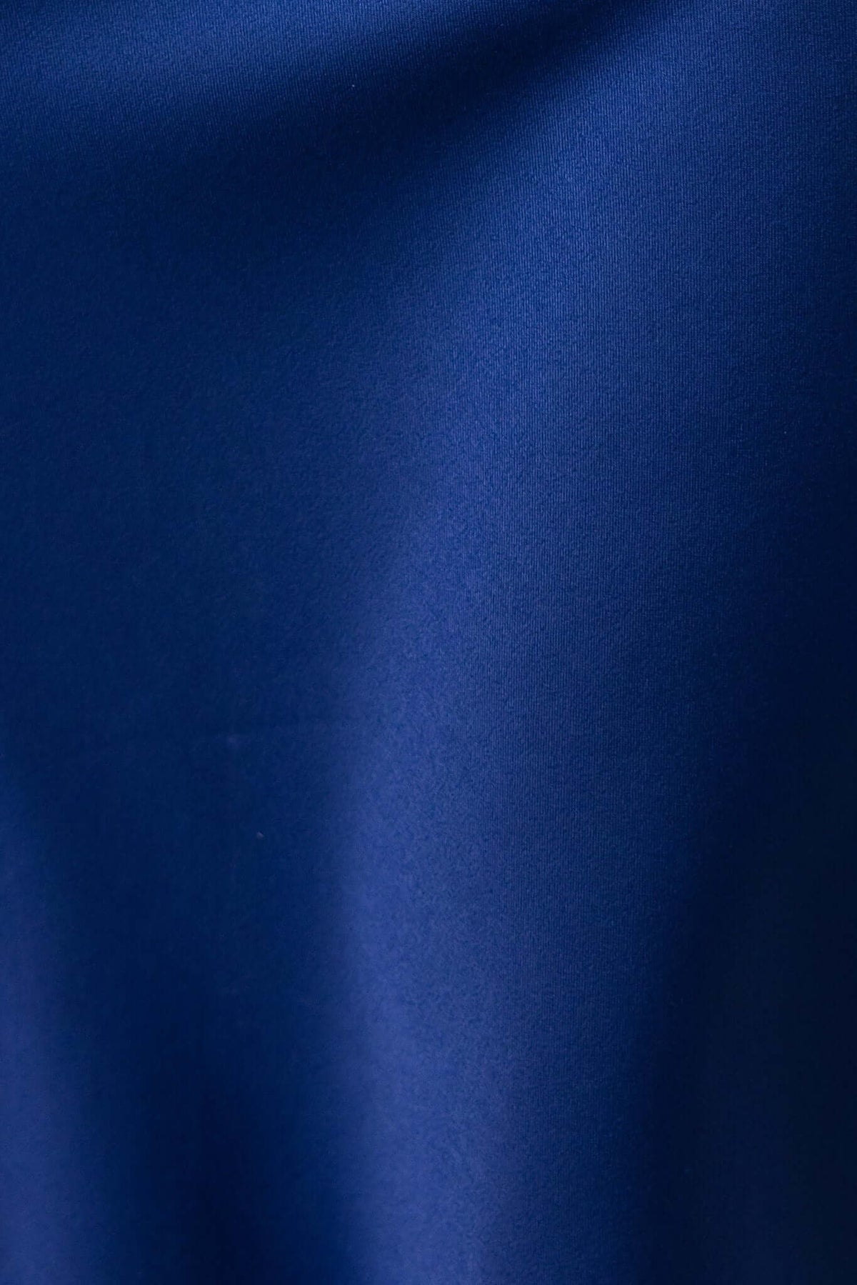 Close-up of smooth navy fabric, perfect for a satin midi dress, showcasing luxurious texture and sheen.