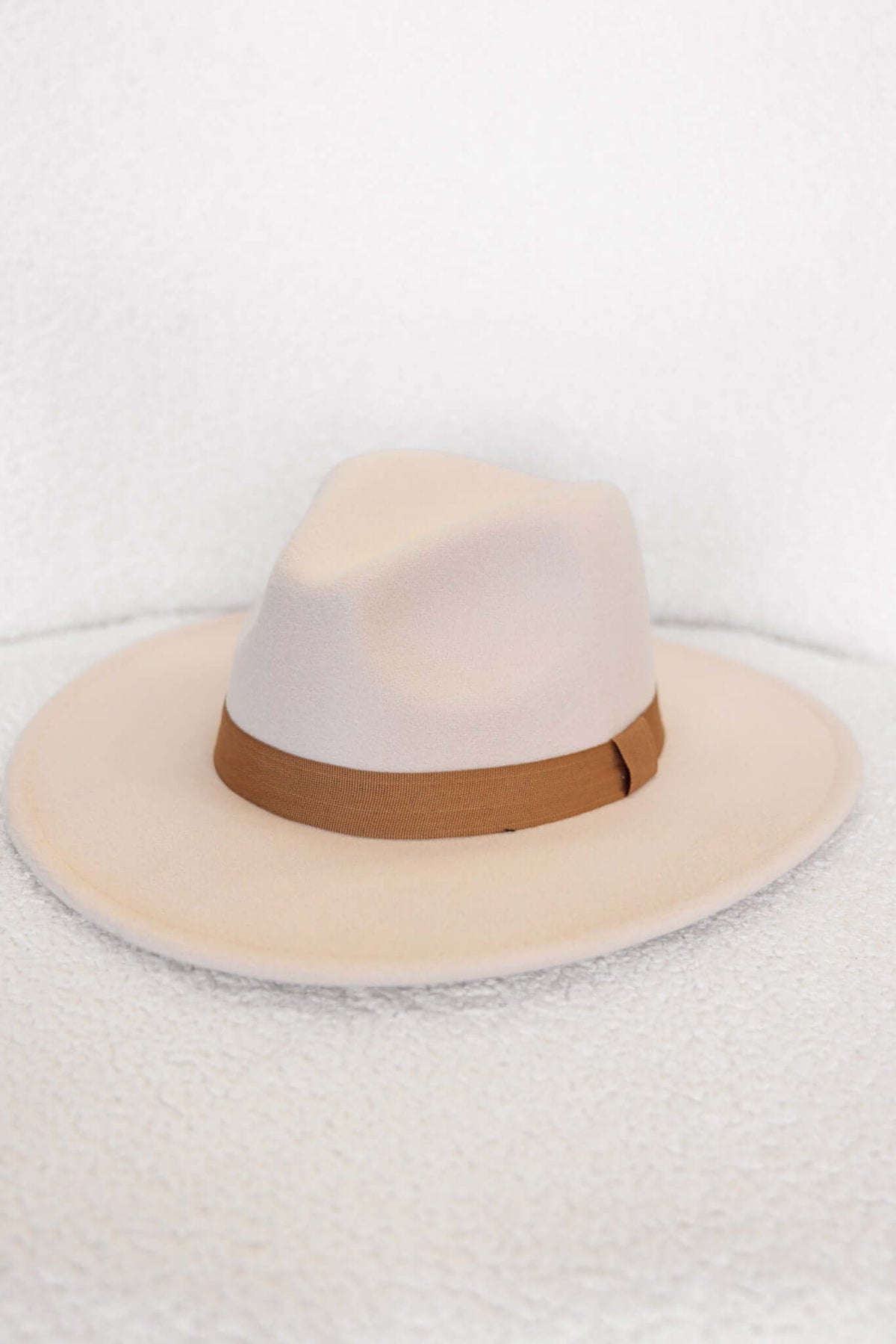 Stylish Austin Hat with a soft beige color and brown ribbon trim, perfect for any casual outfit.