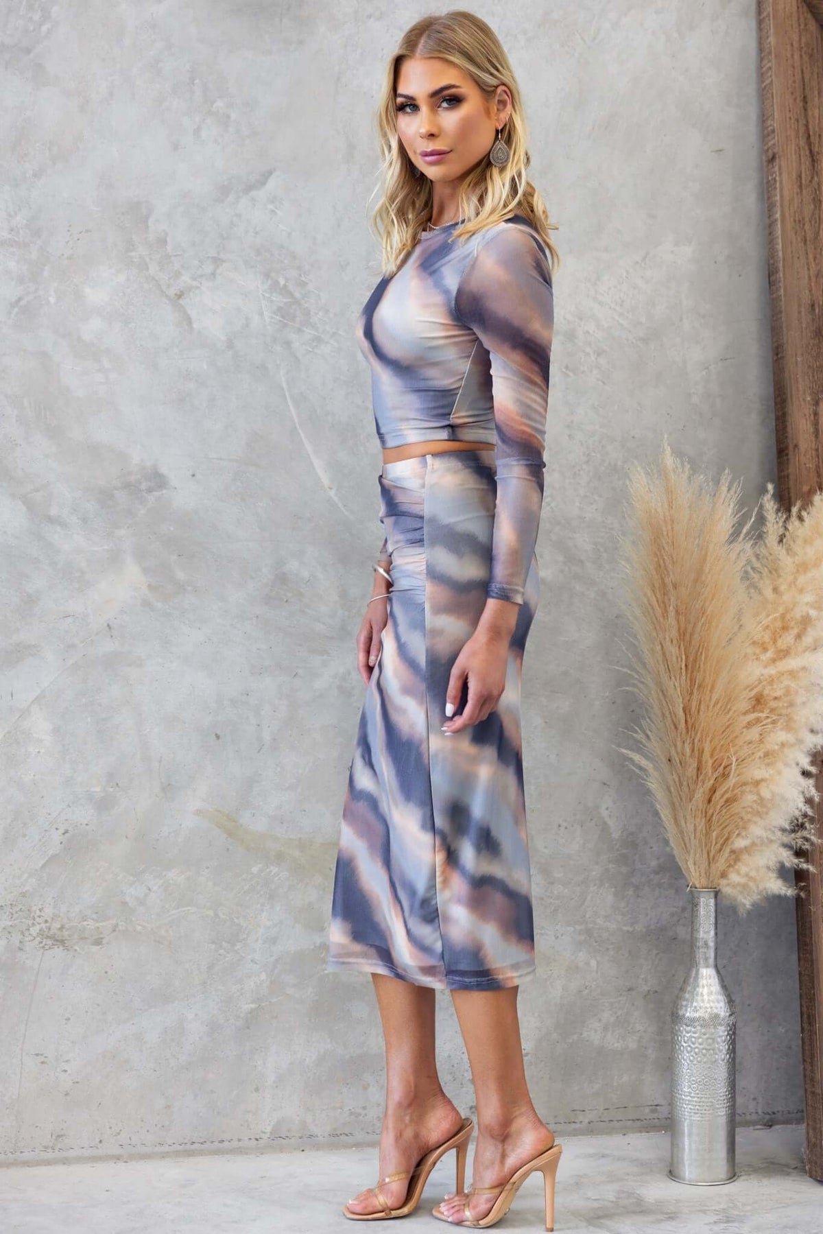 Model wearing the Crunch Time Set featuring a mid-high waist midi skirt and long sleeve top in abstract patterns.