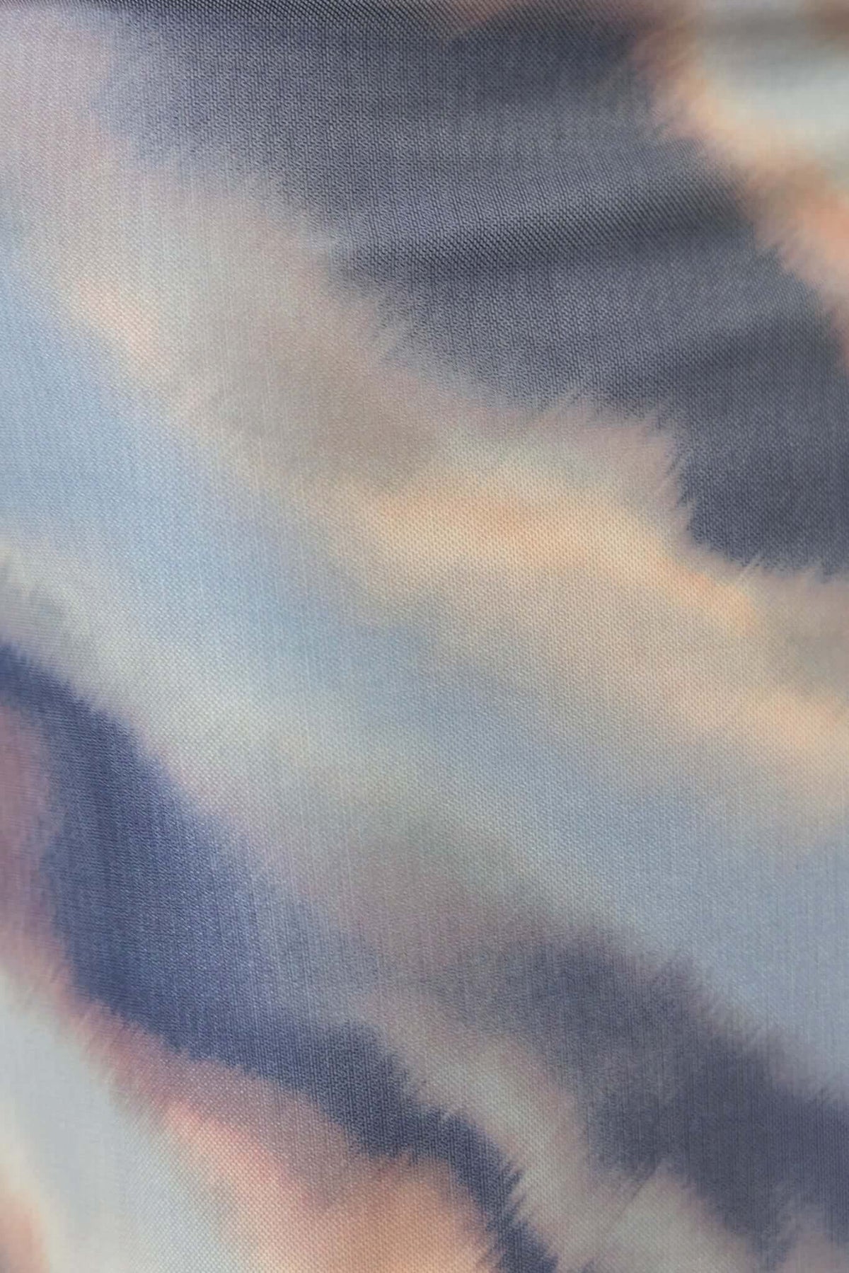 Close-up of soft, stretchy mesh fabric in pastel abstract pattern, perfect for stylish clothing.