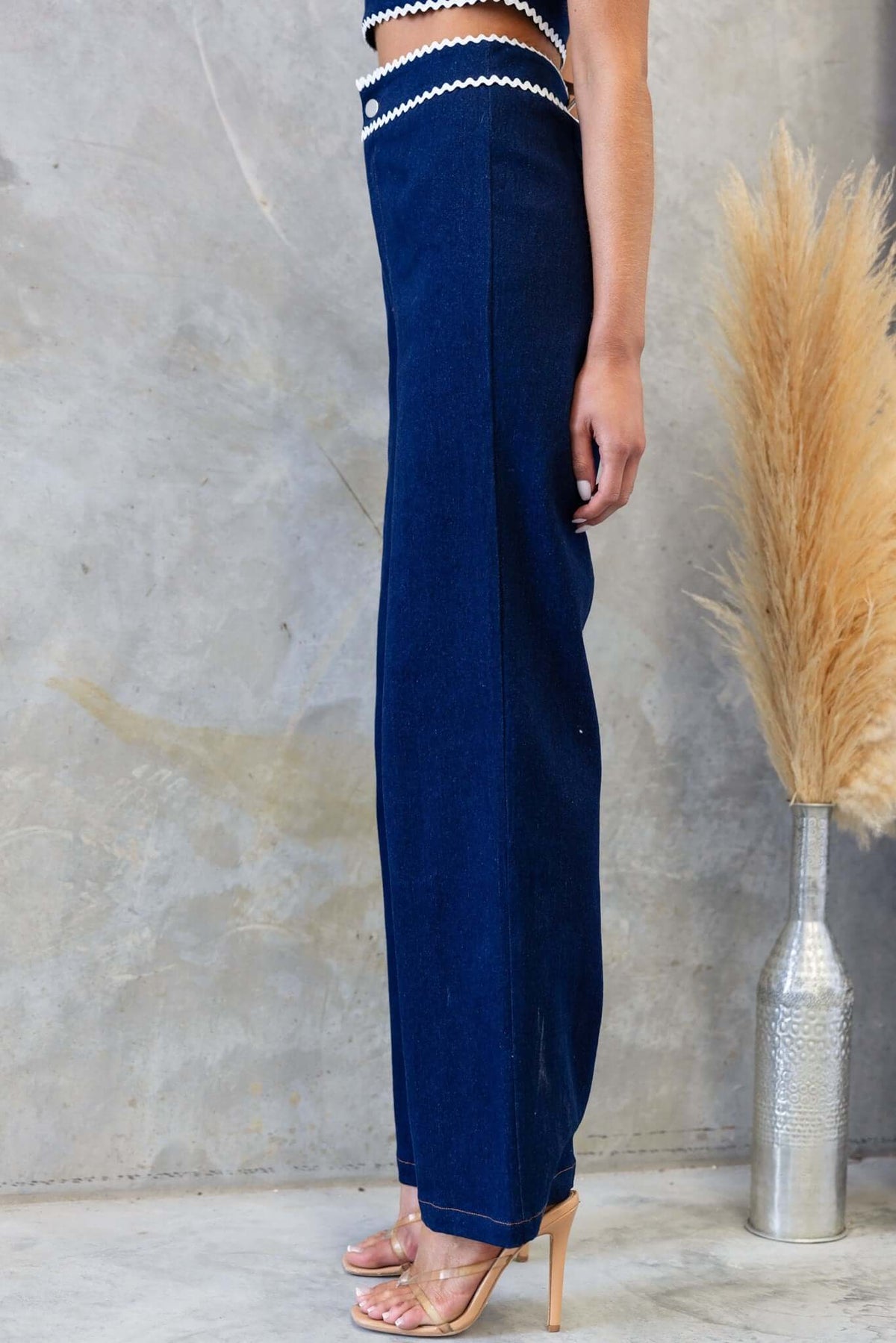 Side view of Favara Jeans in dark denim, featuring a mid-high waist fit and sleek design, perfect for any casual outfit.