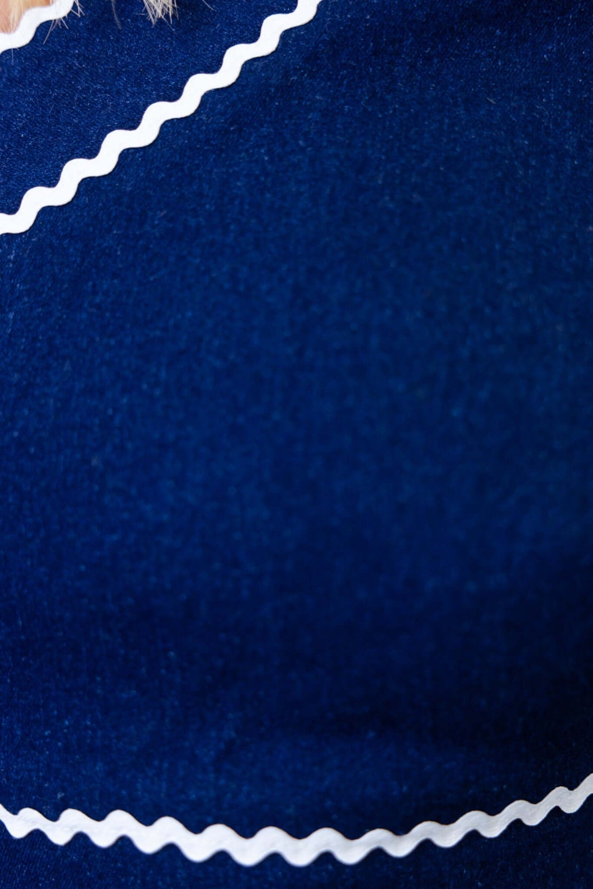 Close-up of dark denim fabric featuring white scalloped detailing, showcasing texture and design of Favara Jeans.