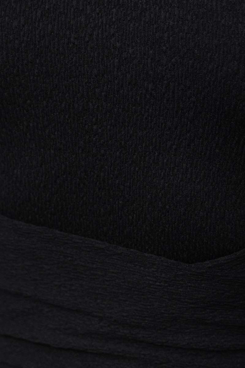 Close-up of the black textured fabric of the Keisha Midi Dress, showcasing the halter neckline and tie waist detail.