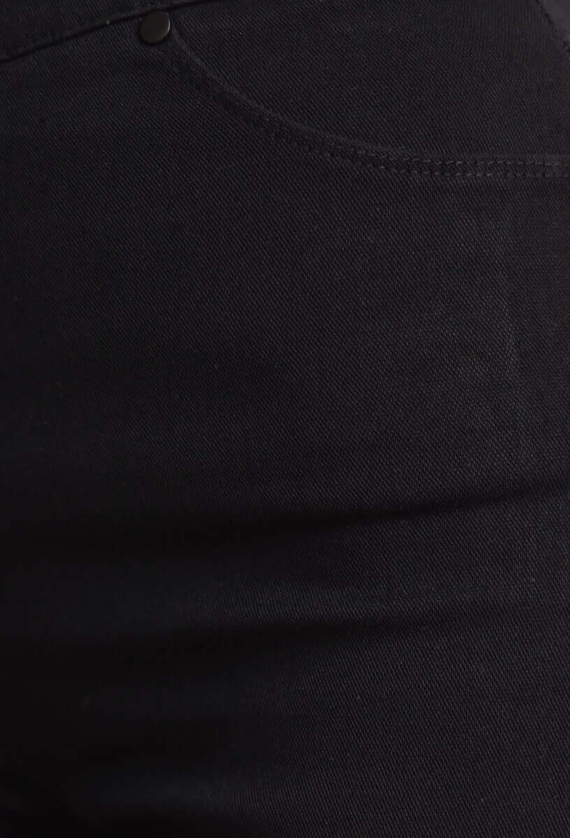 Close-up of black Chicago jeggings showing mid-high waist and faux pocket details.