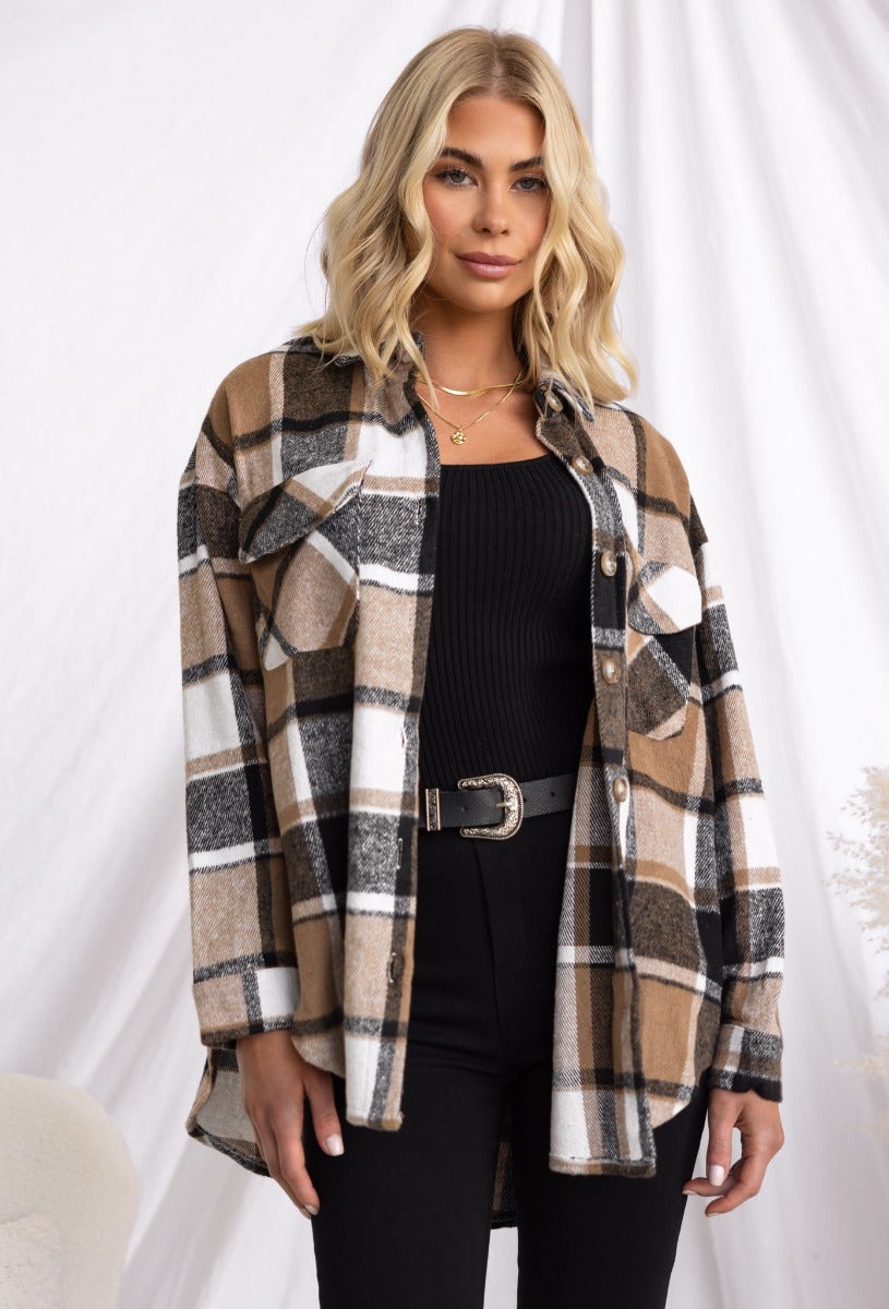 Model wearing a plaid print Gable Shacket, featuring a button-up front and pockets, styled with black pants.
