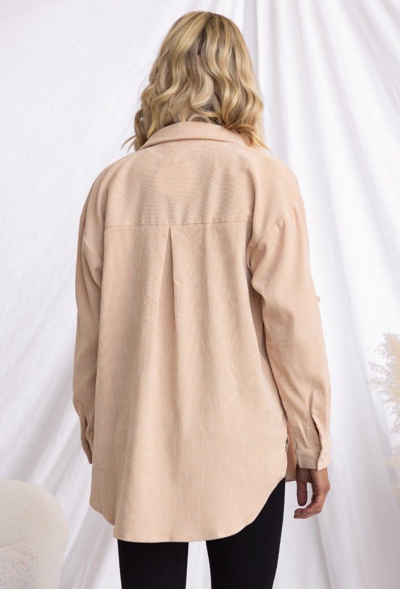 Back view of a model wearing a stone corduroy button-up shirt with a relaxed fit.