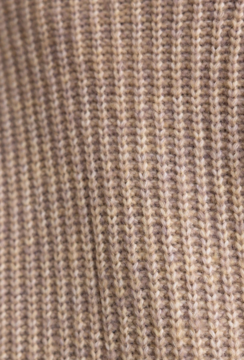 Close-up of cable knit texture in neutral tones, showcasing the soft fabric of the Emerson Cardigan.