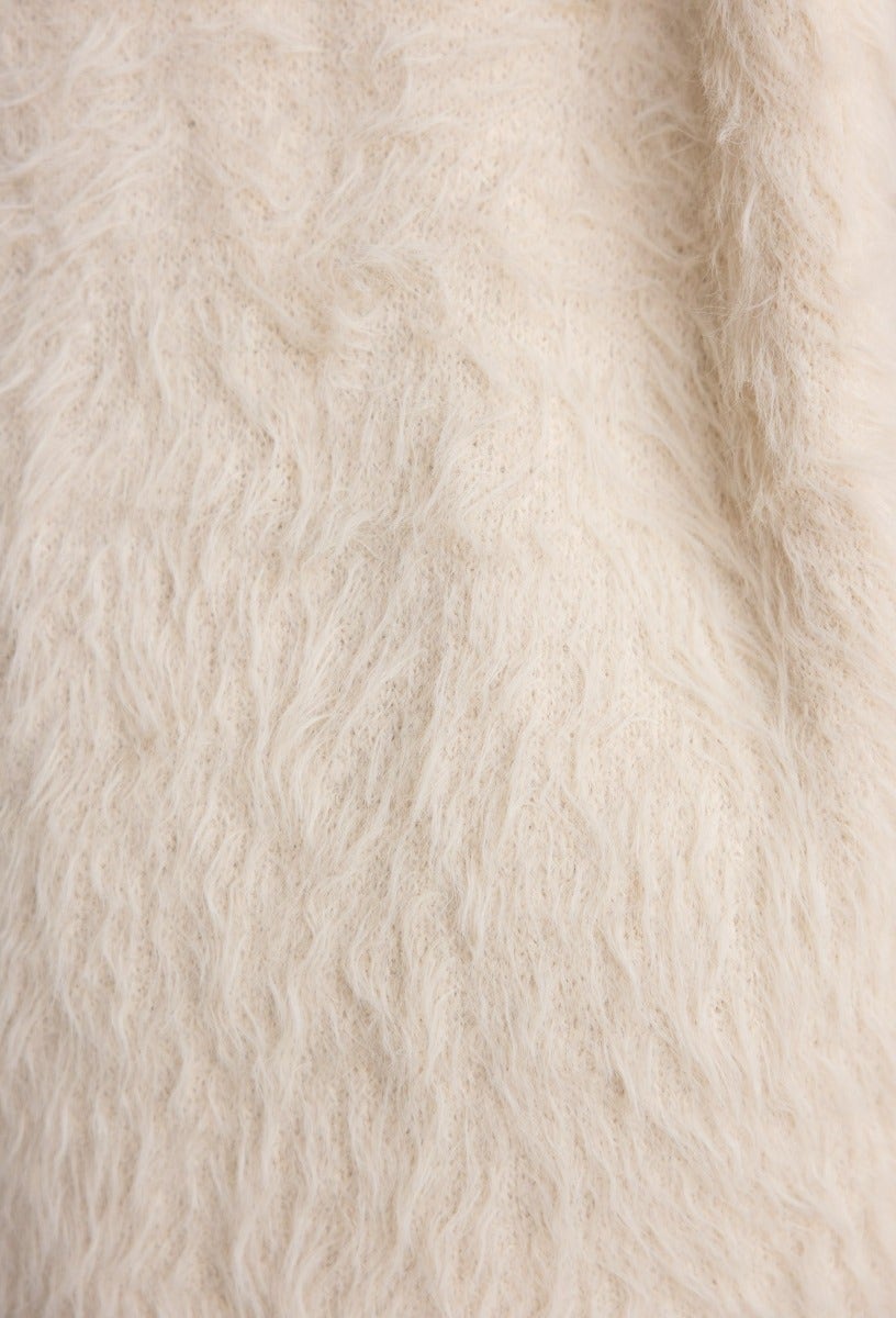 Close-up view of fluffy knit fabric in light cream color, showcasing soft texture ideal for a cozy cardigan.