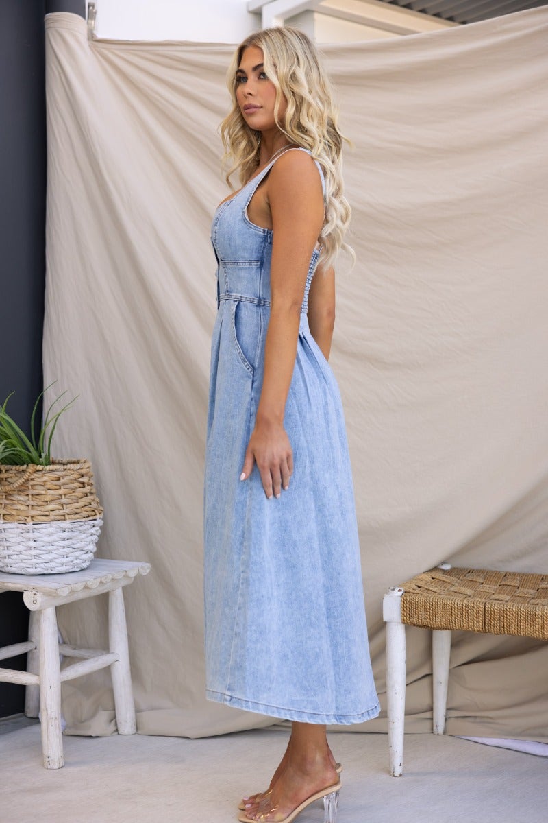 Side view of Tailey Denim Midi Dress featuring faux buttons, elastic back, and side pockets, perfect for stylish summer outings.