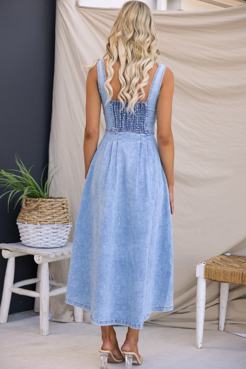 Back view of Tailey Denim Midi Dress showcasing its faux button-up front, elastic back, and pockets.