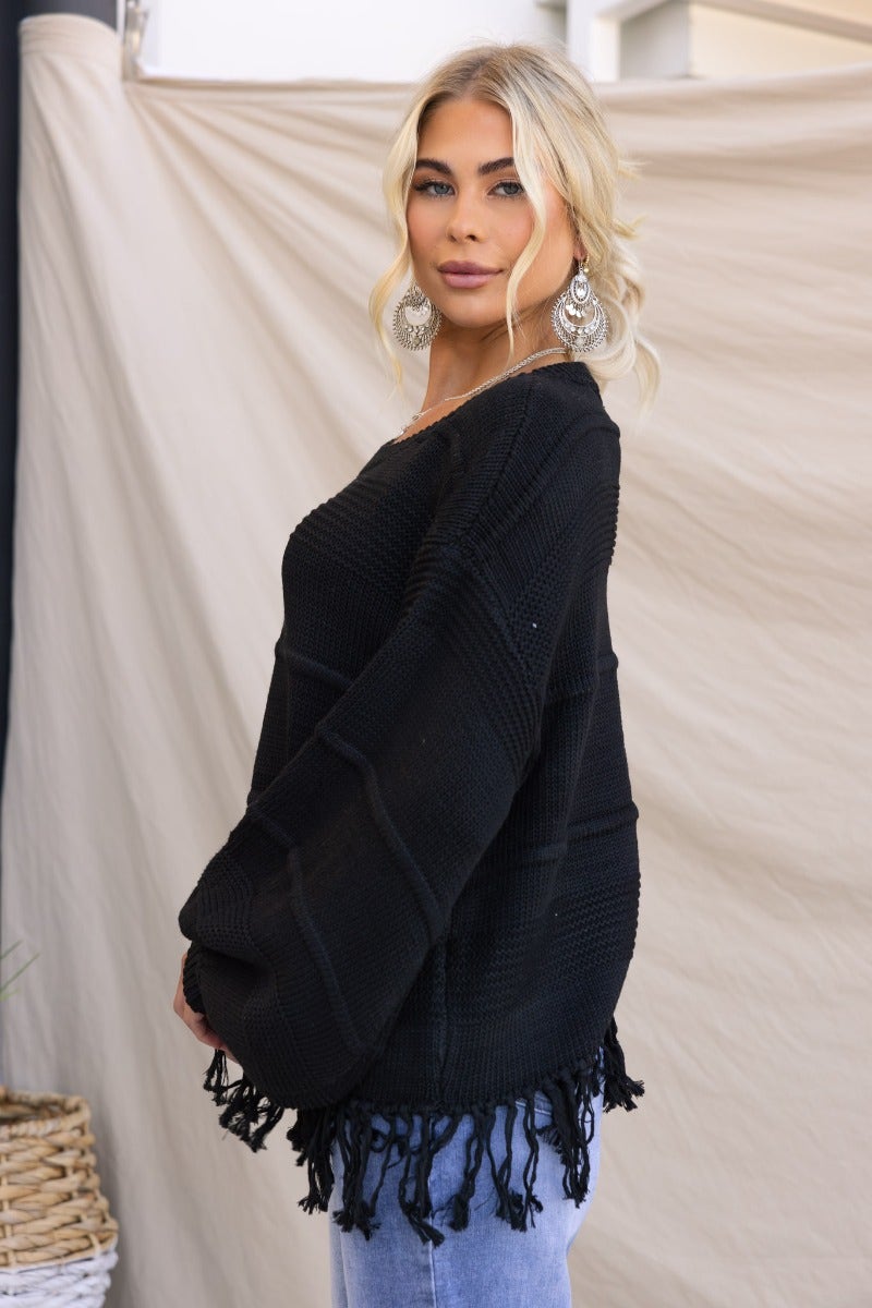 Model wearing the Adela Knit black jumper with tassle detail, showcasing relaxed fit and round neckline.