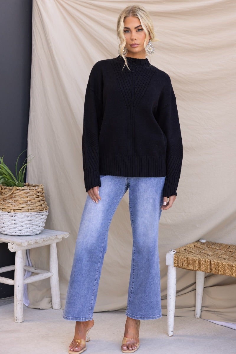 Black ribbed knit Cuba jumper with mock neckline, styled with light blue jeans in a relaxed fit.