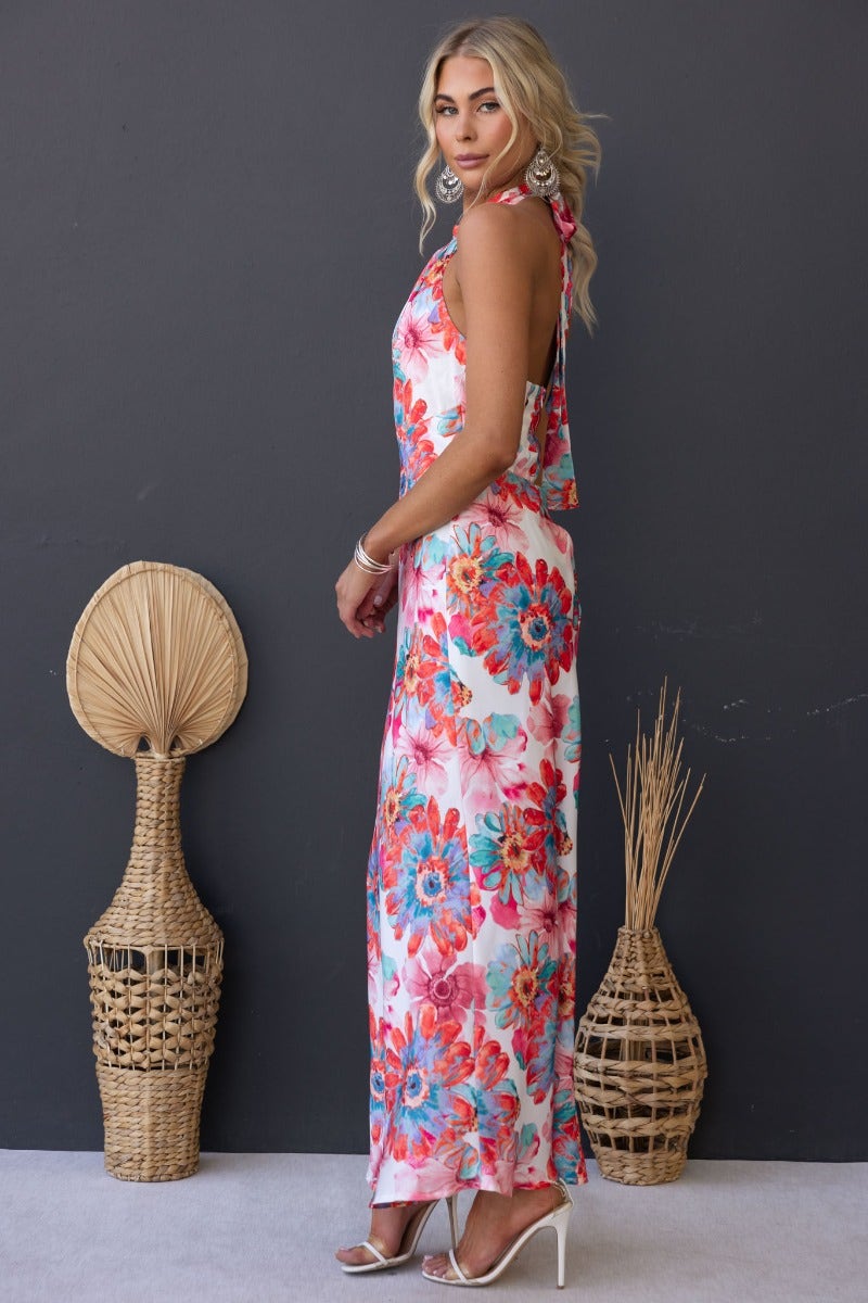 Model wearing a floral print satin maxi dress with high tie neckline and side anti-slip details, displayed against a dark background.