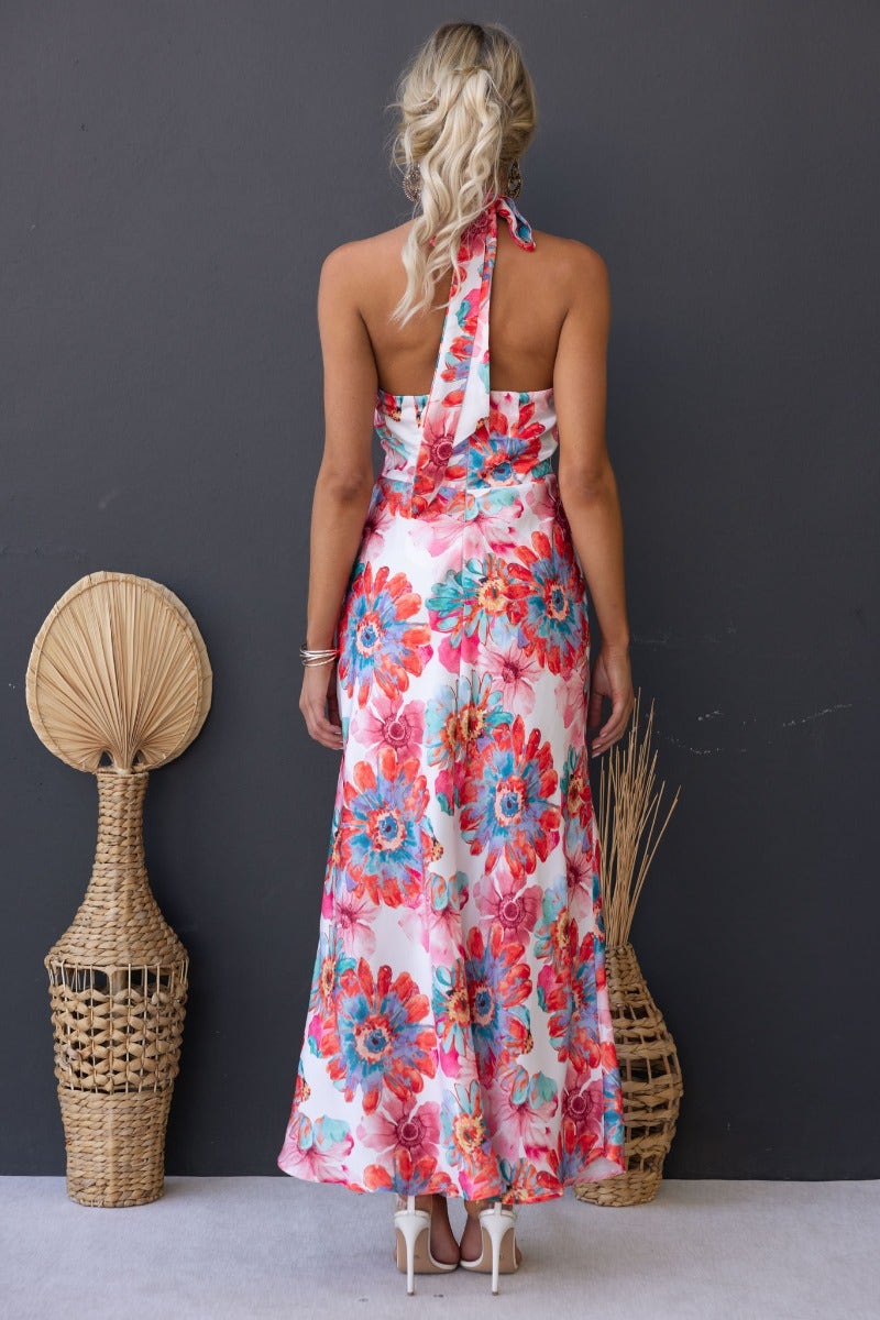 Back view of a floral print satin maxi dress with halter neck, featuring vibrant colors and elegant design.