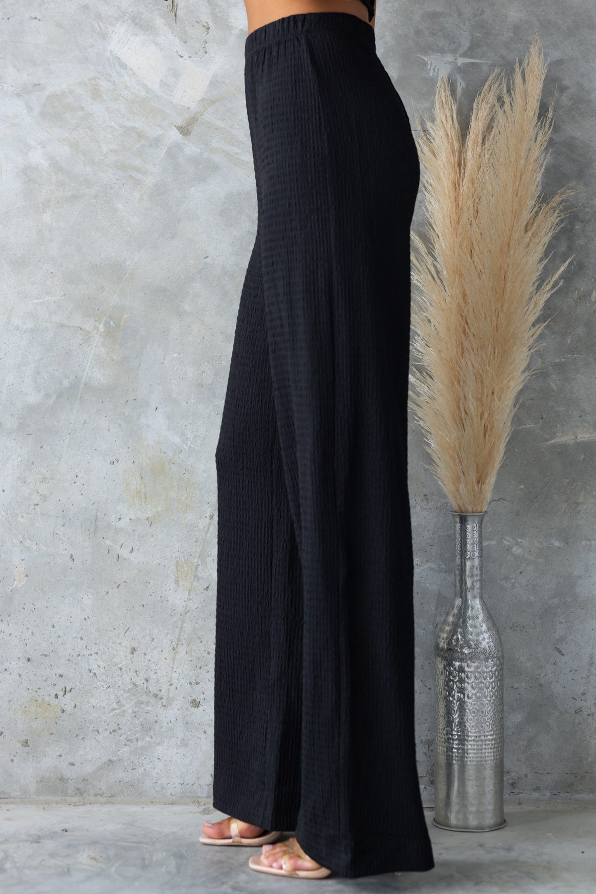 Black mid-high waist Sachie Pants with elastic waistband, lightly textured, made of stretchy polyester.