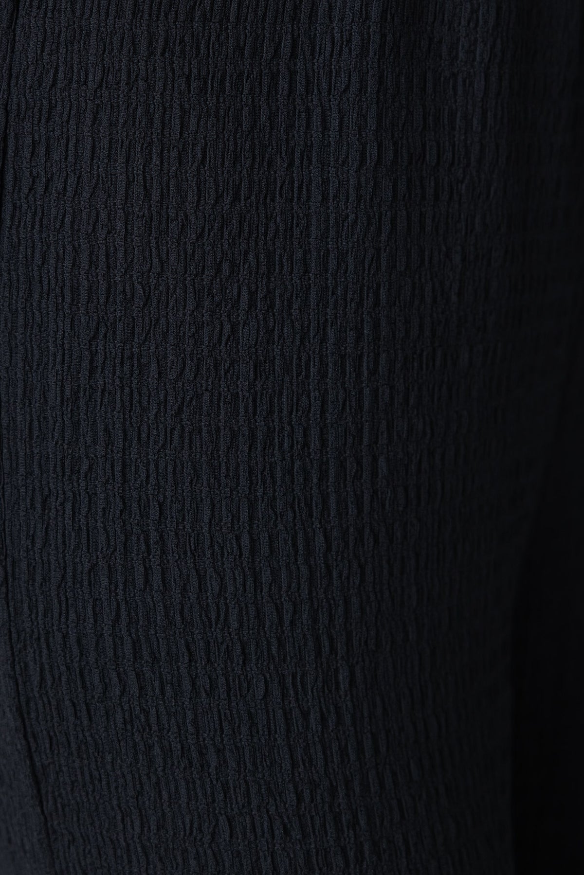 Close-up of textured black Sachie Pants showcasing the lightly textured material and mid-high waist design.