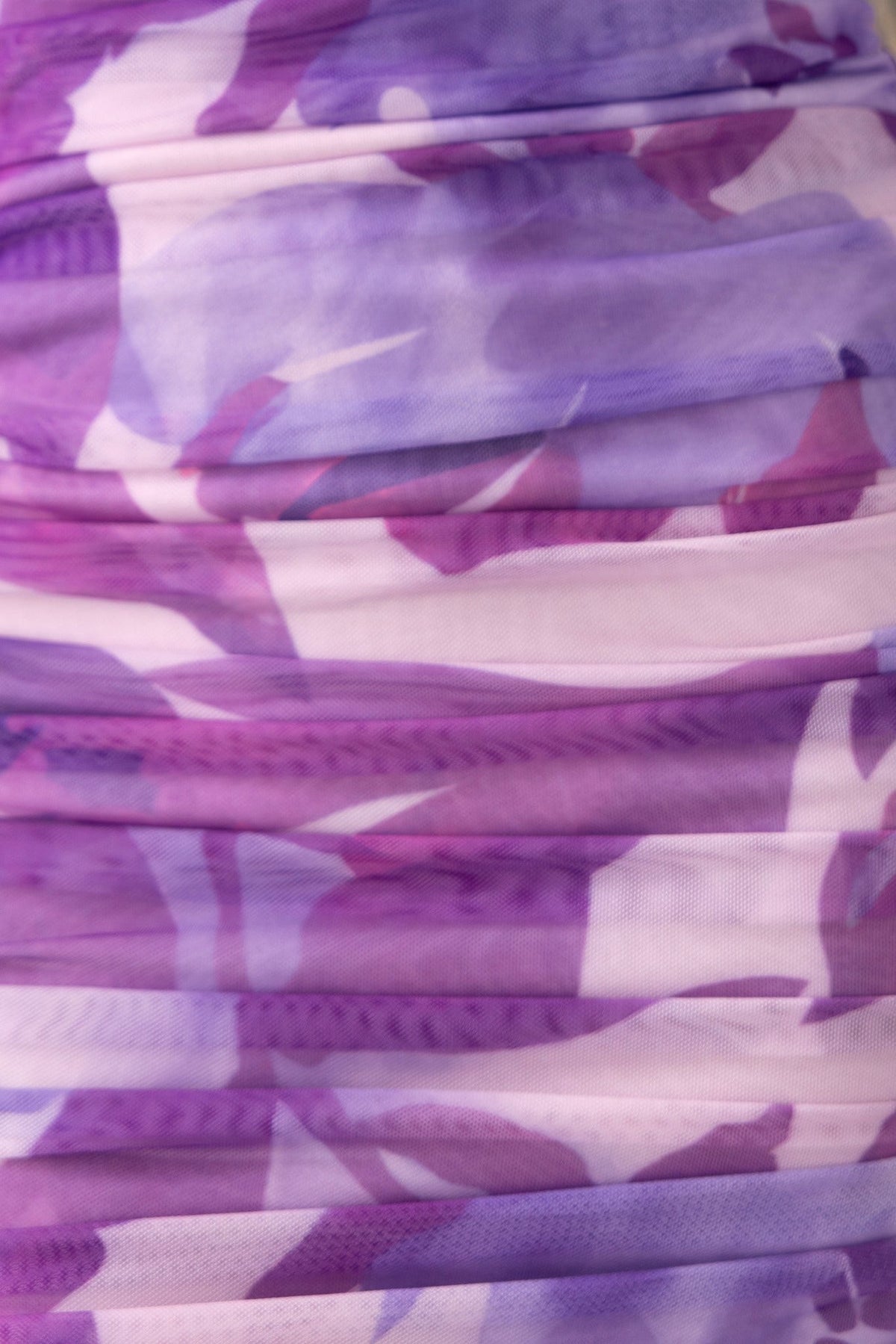 Close-up of purple and lilac mesh overlay fabric with ruched detailing for the Dayara Midi Dress.