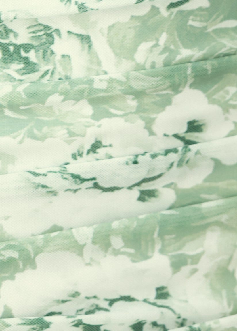 Close-up of floral print fabric in green hues, showcasing the texture and pattern of the Overboard Midi Dress.