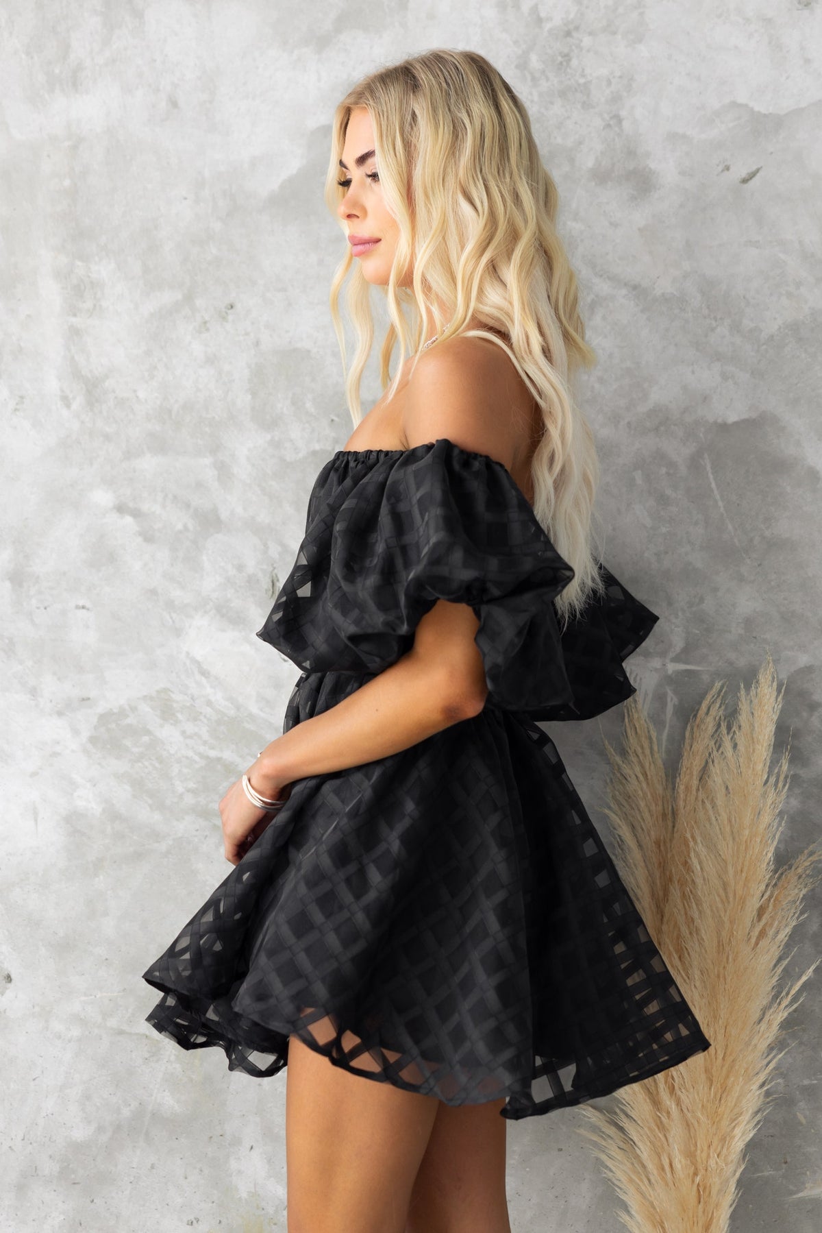 Zerali black off-shoulder dress with puff sleeves and lace detailing, styled against a neutral background.