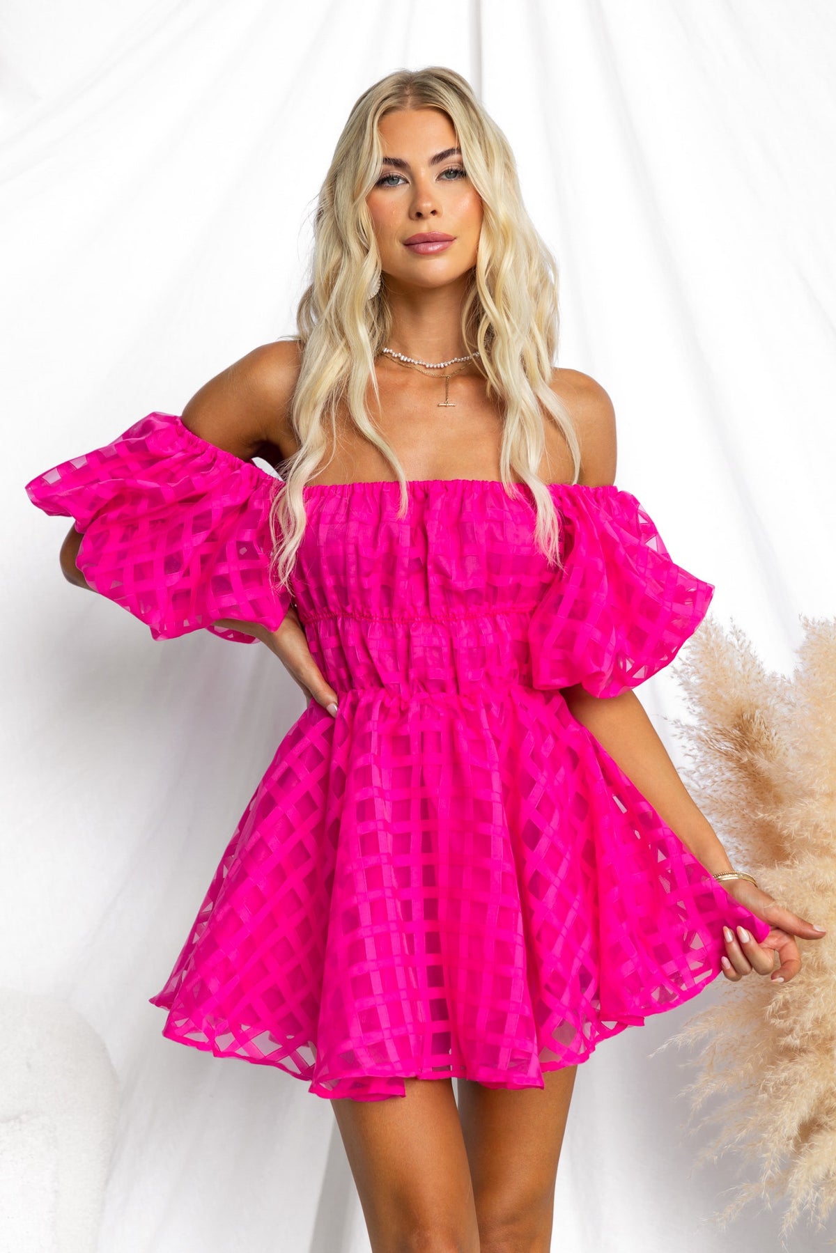 Zerali Dress in bright pink, featuring an off-shoulder design, puff sleeves, and a flirty short skirt.