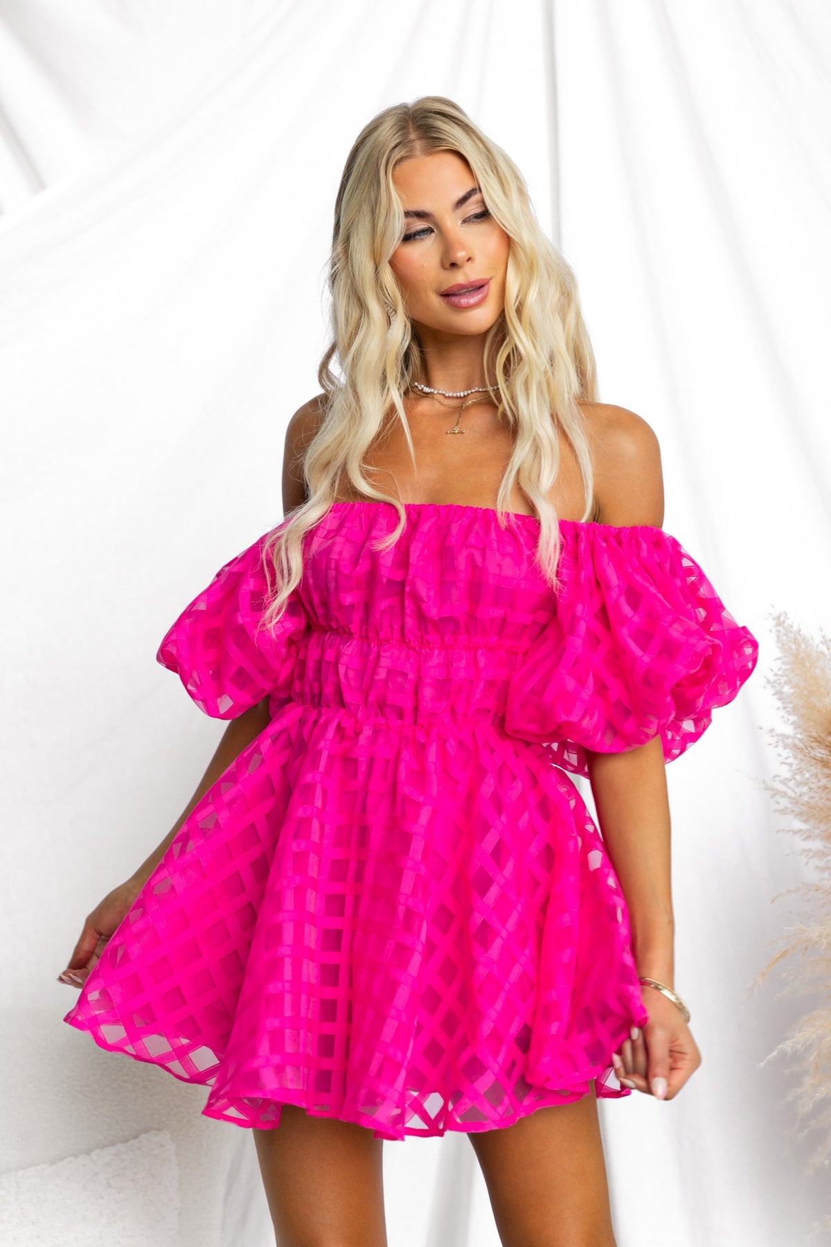 Zerali Dress in vibrant pink, featuring off-shoulder design, puff sleeves, and a flared skirt.