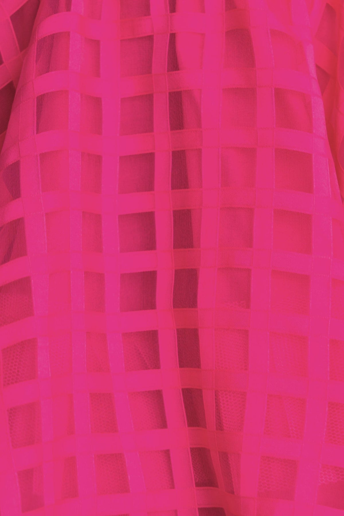 Close-up of a vibrant pink fabric with a grid pattern, featuring a sheer overlay, perfect for trendy dress designs.