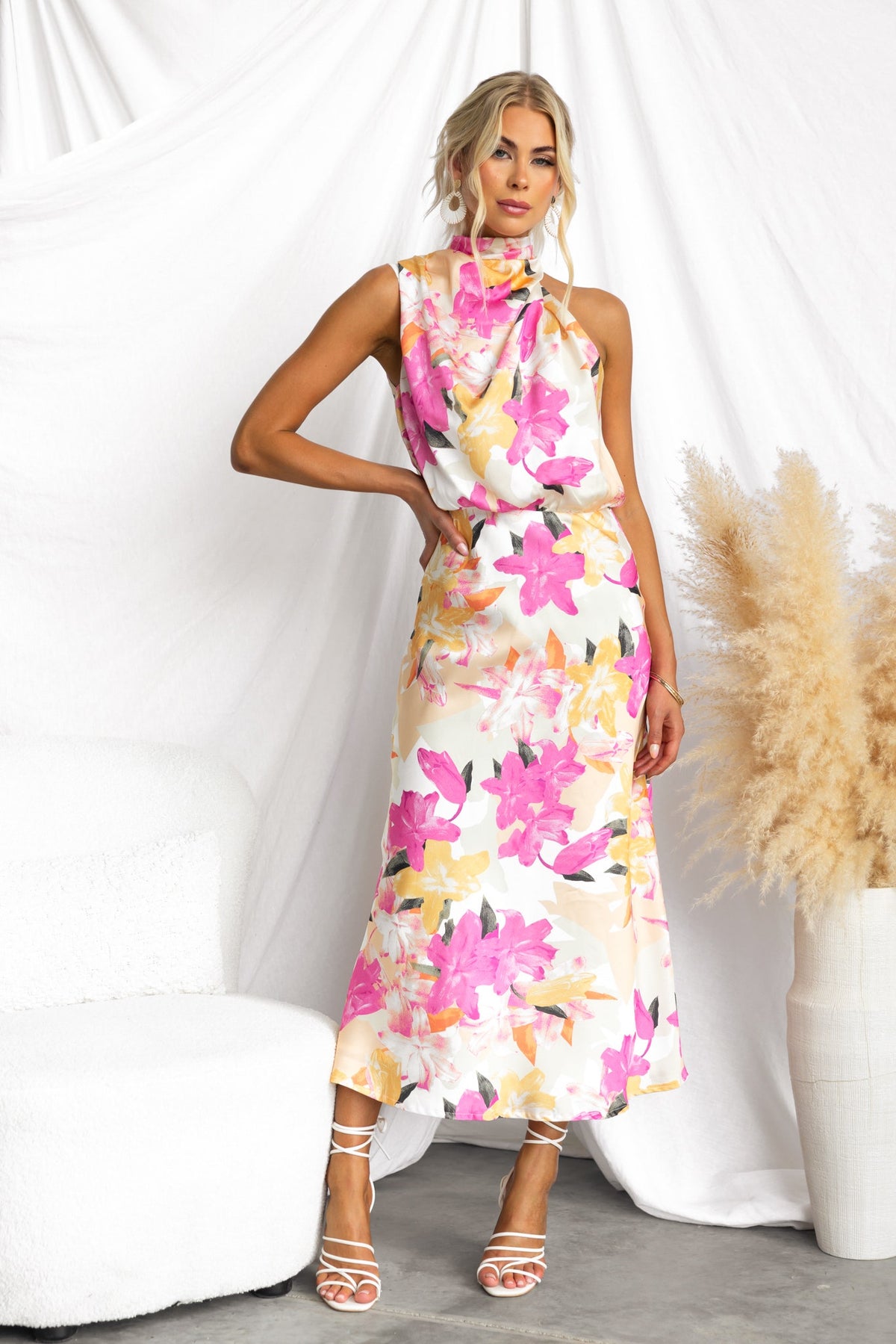 Model wearing Irisse Midi Dress with floral print, high neckline, and button details, styled against a neutral backdrop.