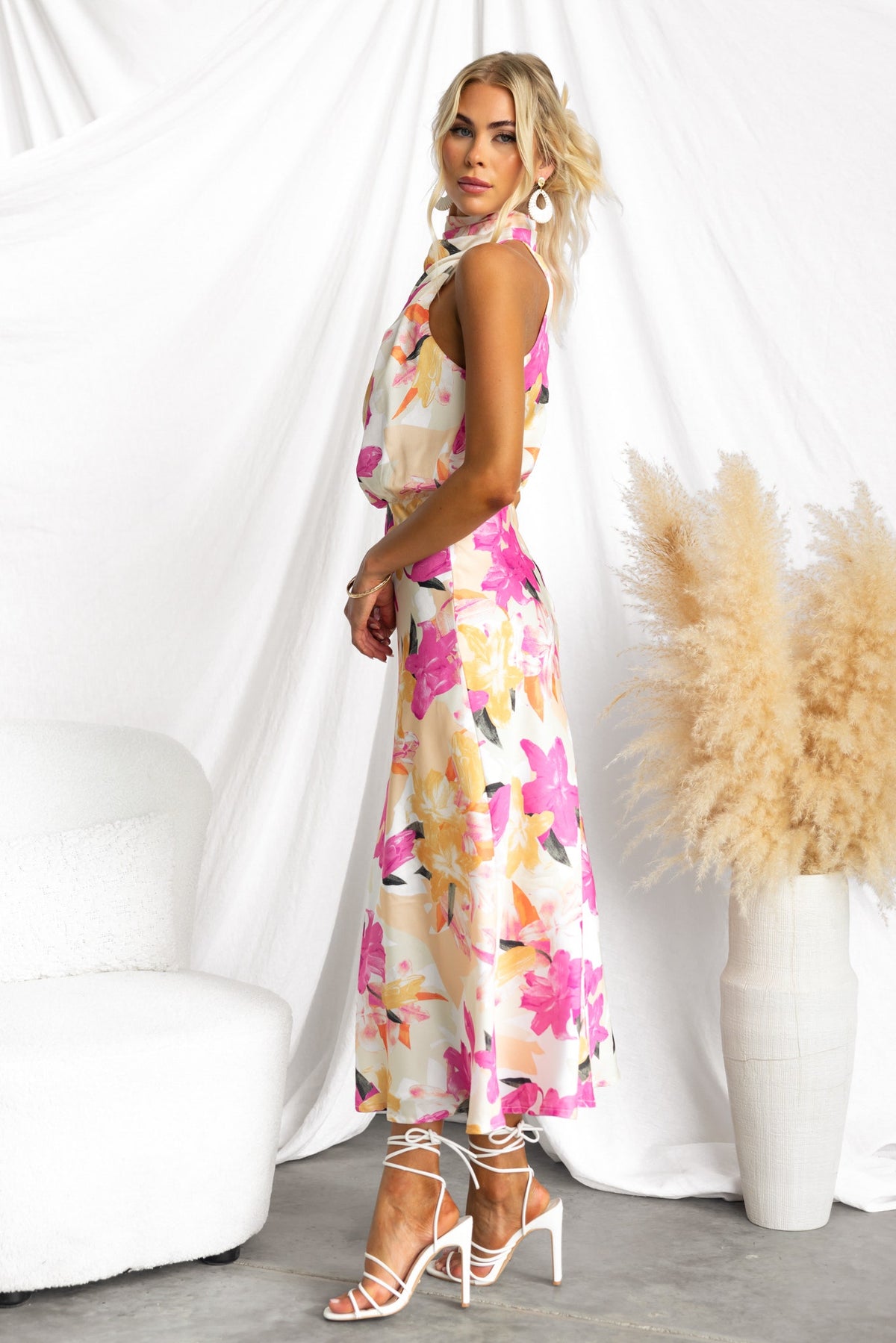 Irisse Midi Dress featuring a floral print, high neckline, and relaxed fit, styled with strappy white heels.
