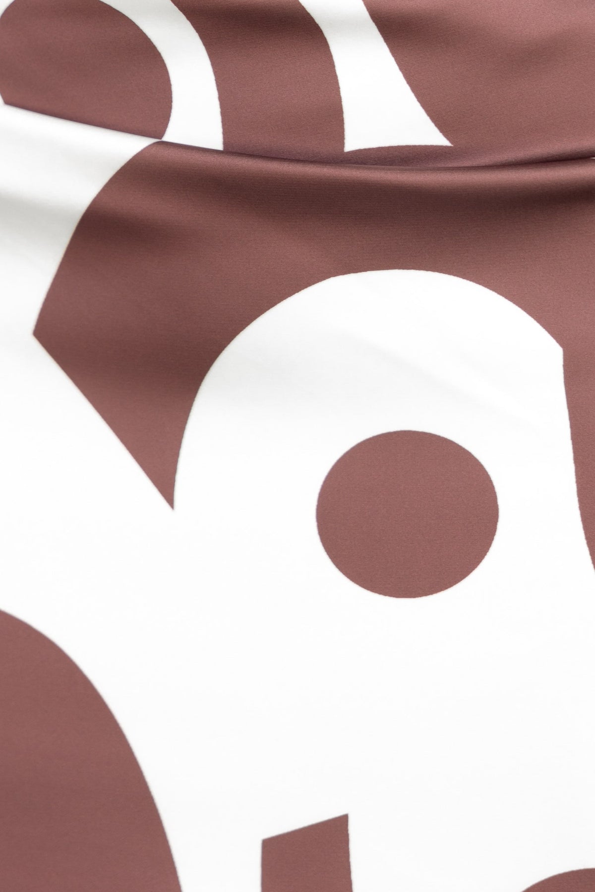 Close-up of Vella Maxi Skirt's satin fabric featuring a brown and white abstract design.