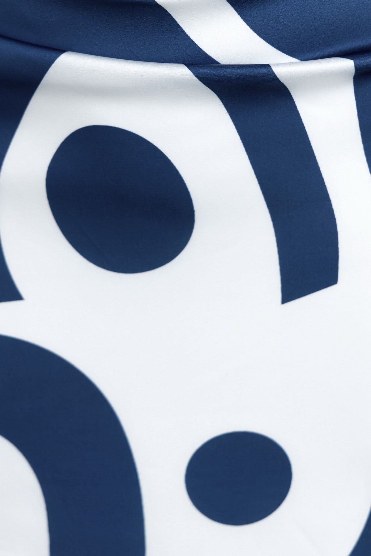 Close-up of Vella Top fabric featuring modern graphic pattern in navy blue and white, showcasing its satin finish.