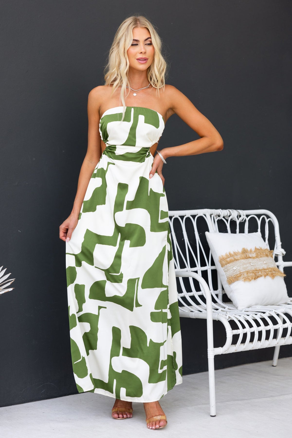 Strapless abstract print maxi dress in green and white, featuring a tie back and side split, styled by a model.