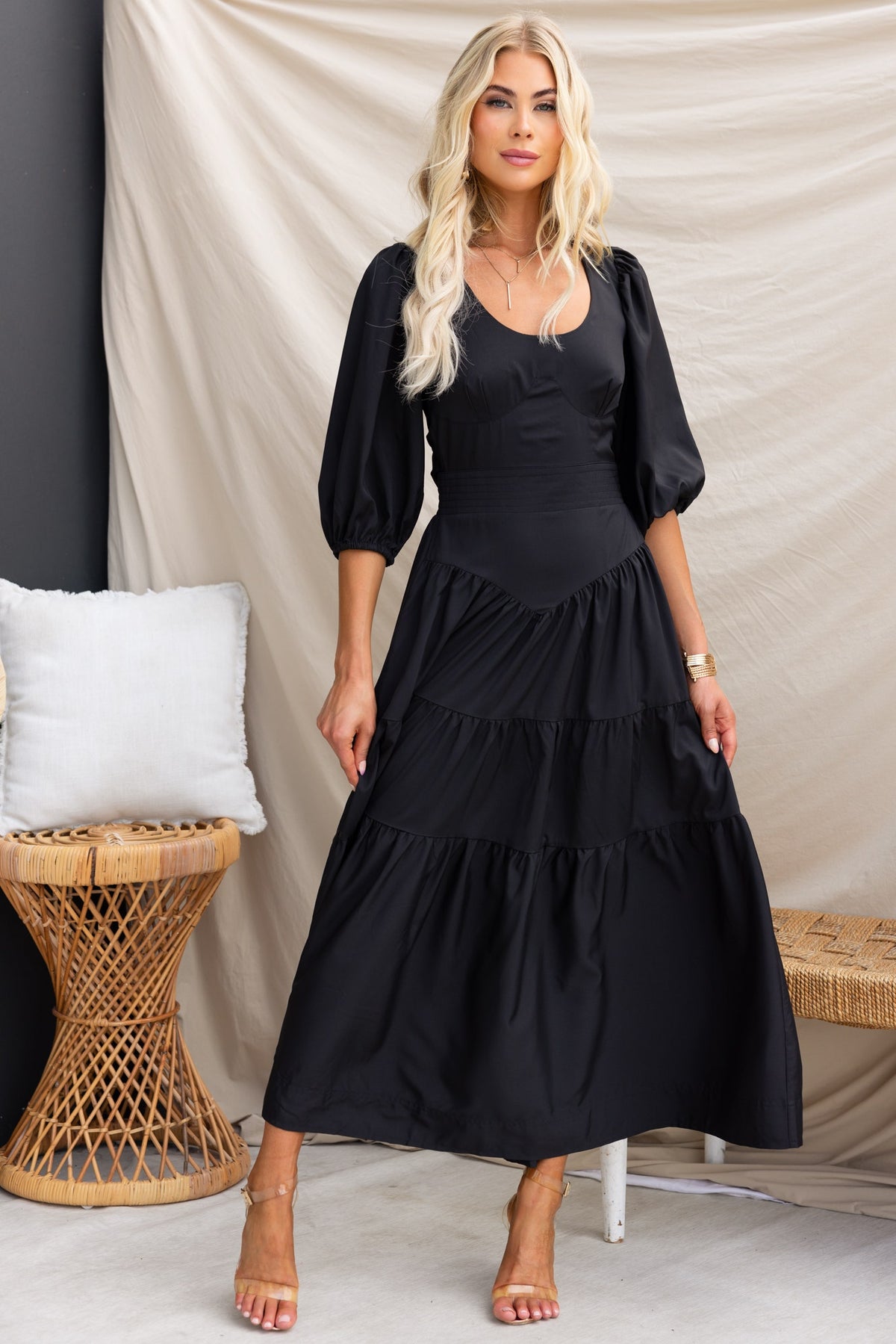 Elegant black Merle midi dress featuring round neckline, puff sleeves, and tiered skirt, perfect for stylish occasions.