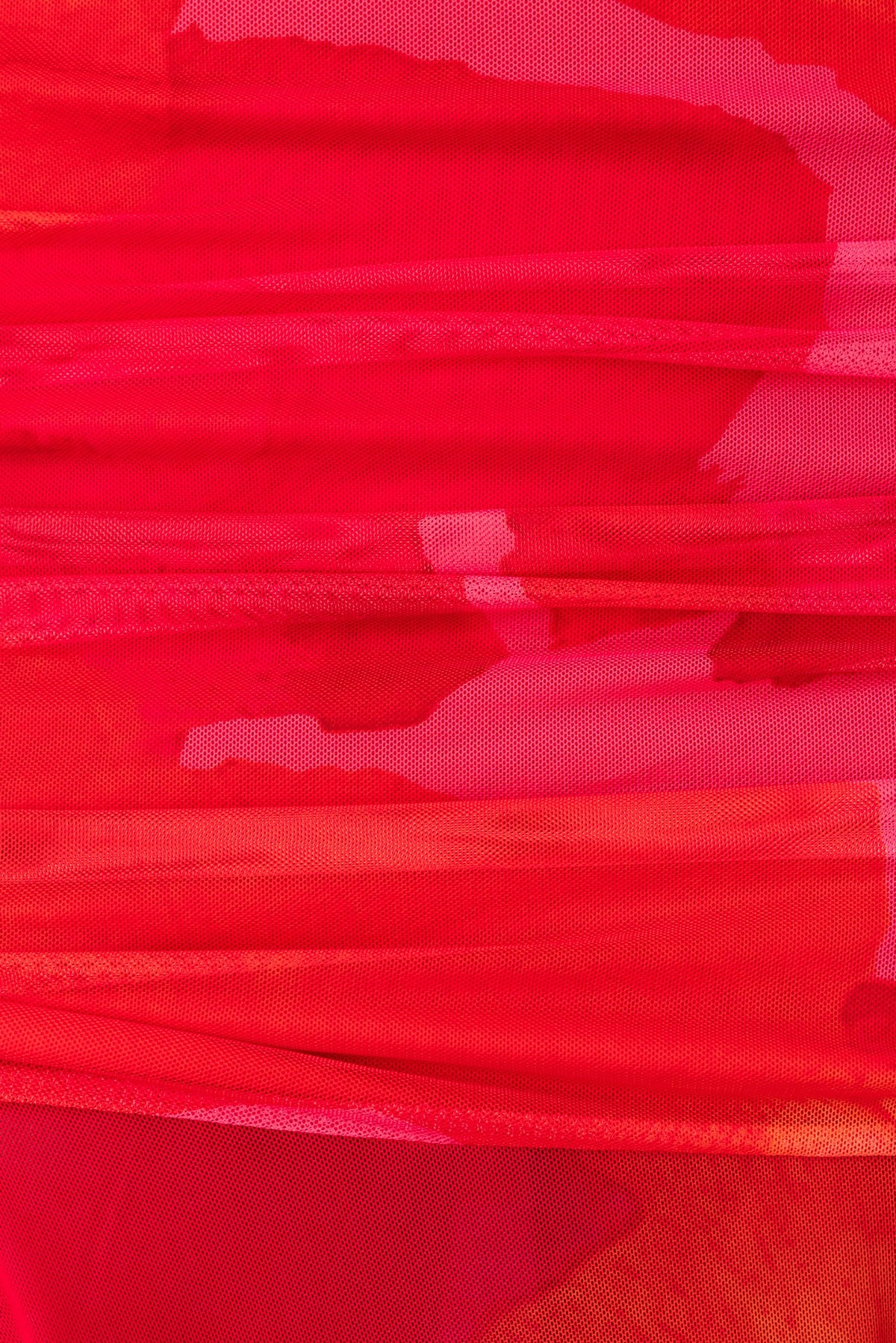 Close-up of vibrant red mesh overlay fabric with a textured appearance, perfect for a stylish midi skirt.
