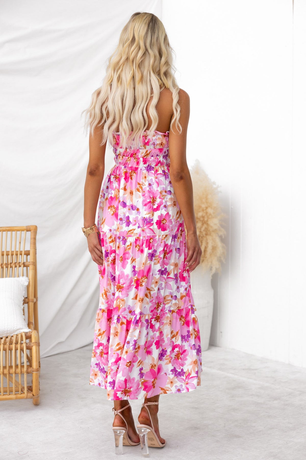 Back view of a floral print Qorla midi dress with strapless design and tie detail at the bust, showcased on a model.