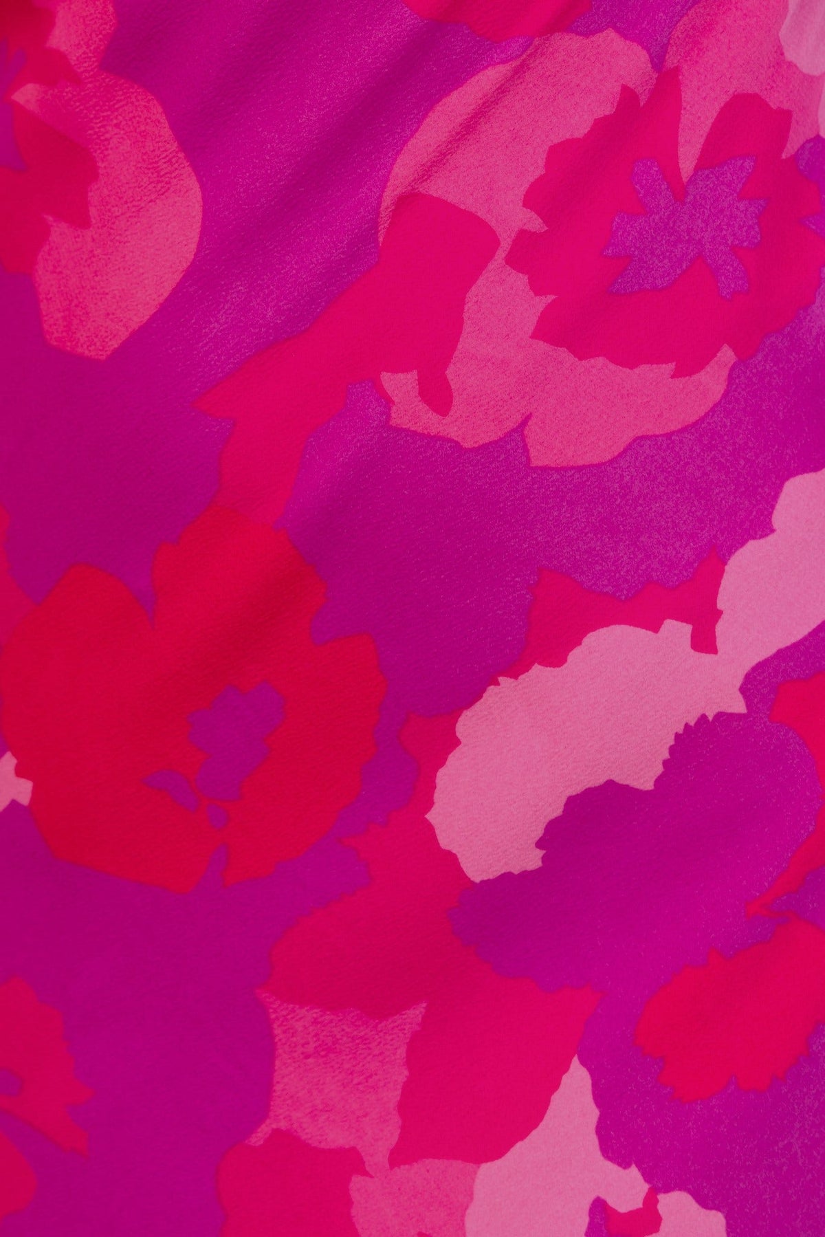 Close-up of vibrant floral print in shades of pink on fabric of a maxi dress, showcasing texture and color details.