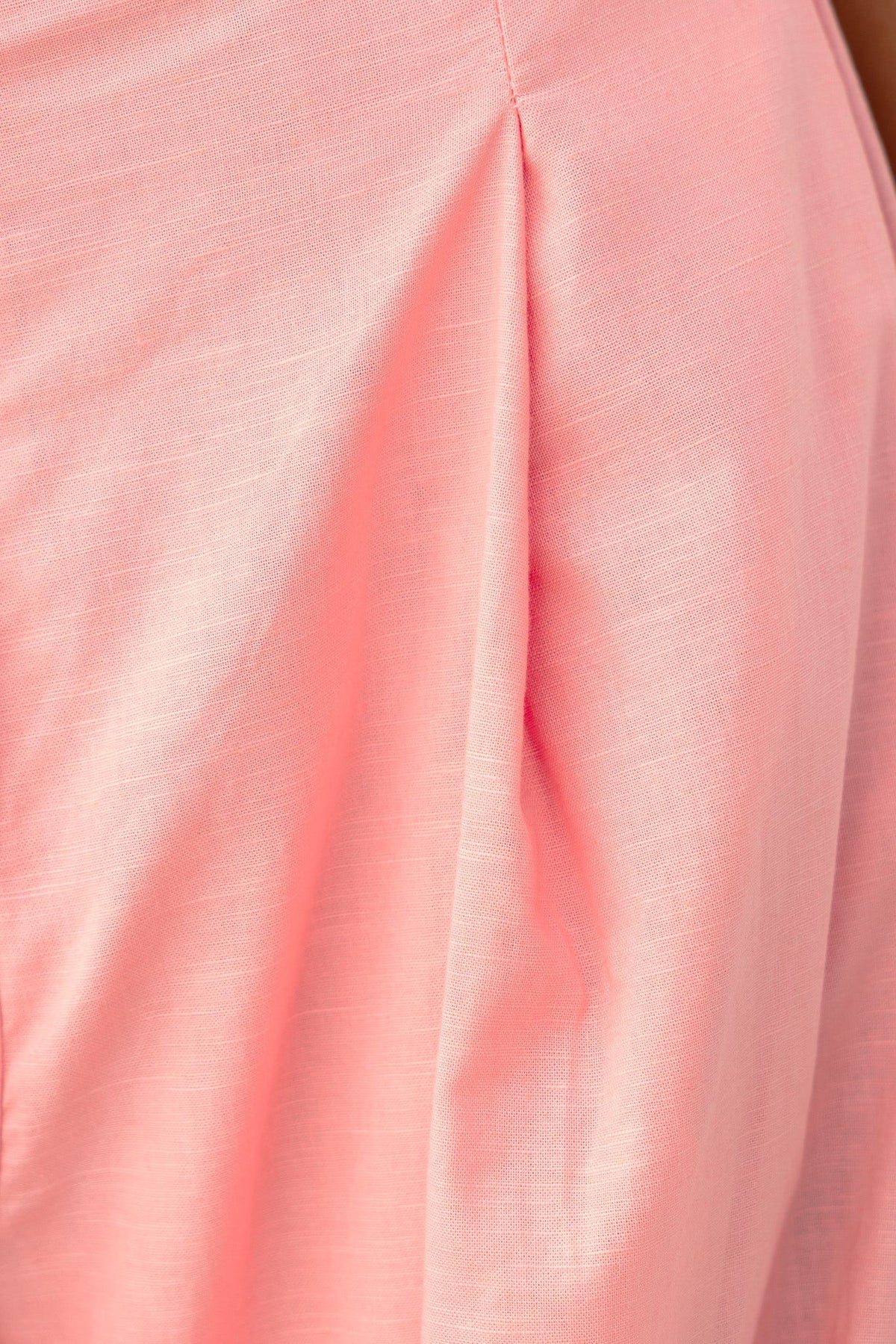Close-up of the soft linen-like fabric in a light pink color, showing detailed pleating design.