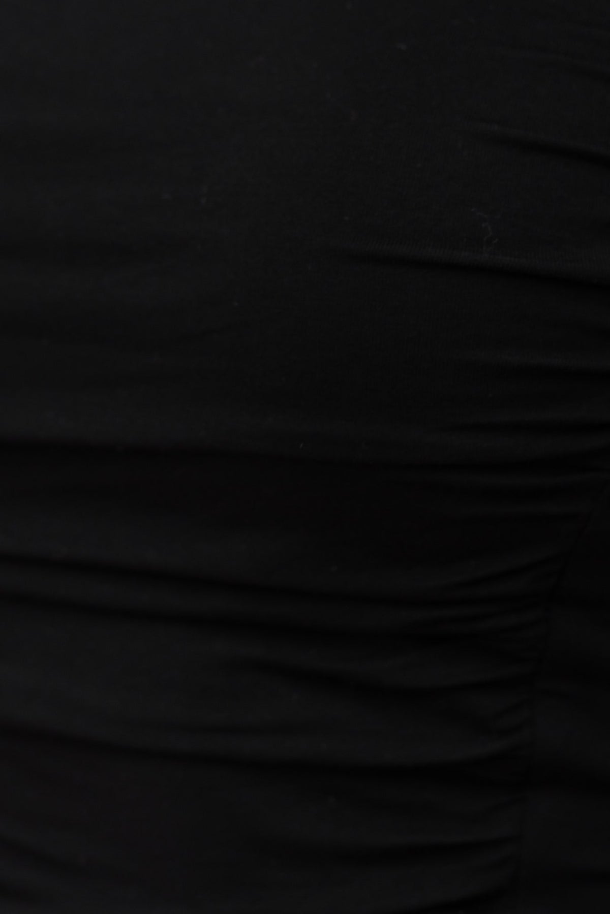 Close-up of soft black fabric with stretch, showcasing a gathered texture and sleek appearance.