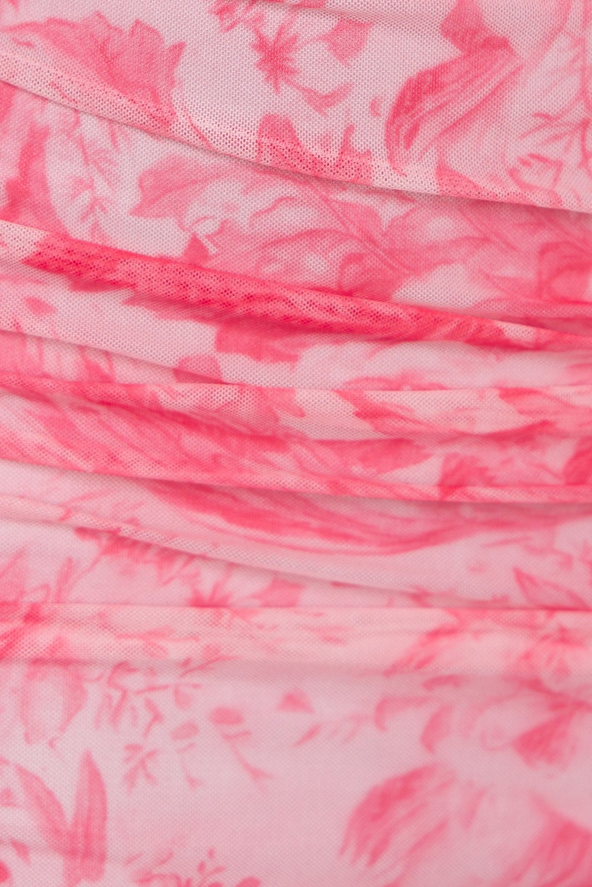 Close-up of soft pink floral print fabric with ruching, featuring delicate patterns and textures, ideal for a maxi dress.